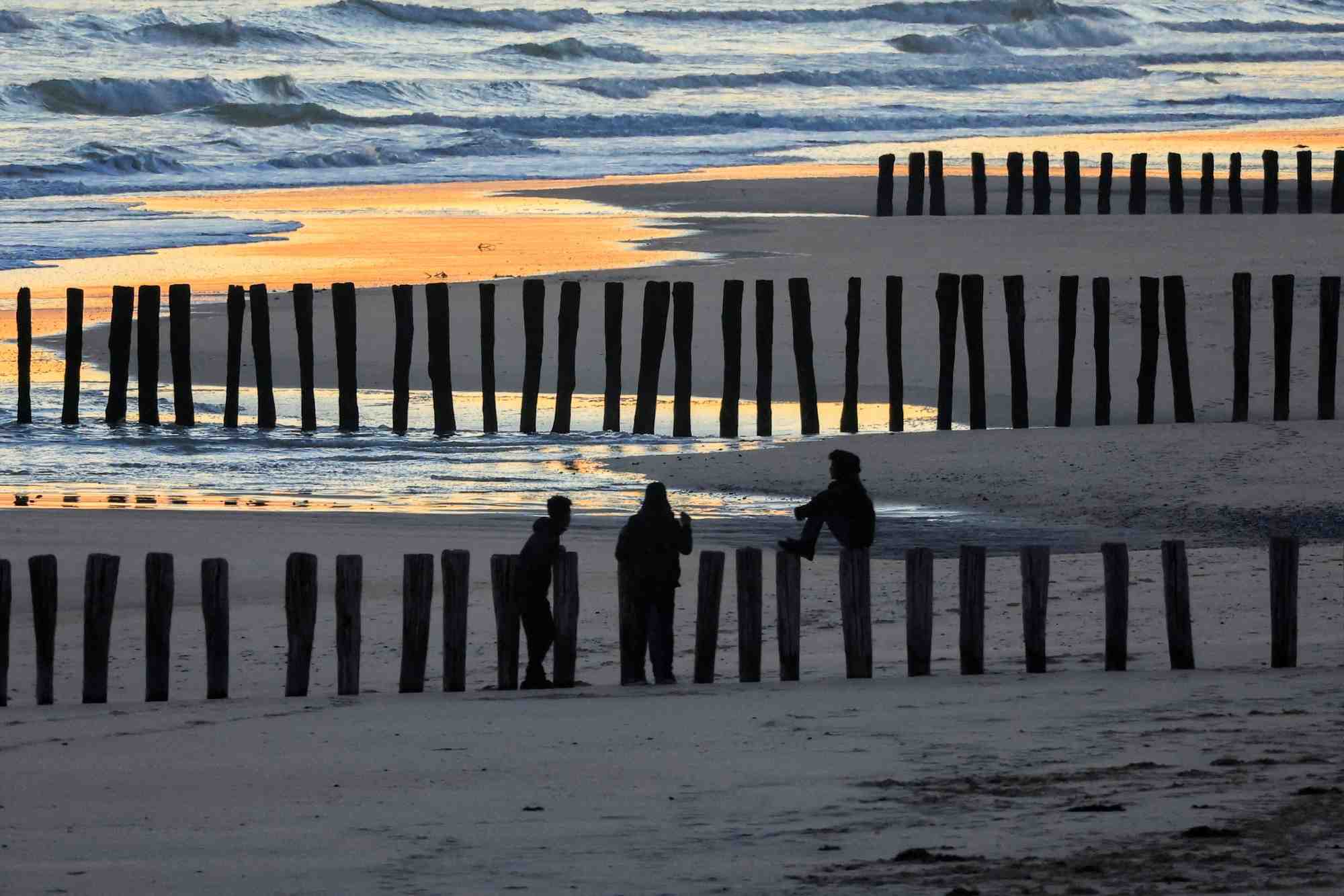 Vue de migrants sur la plage au lever du soleil apres l'echec d'une tentative de traversee de la manche vers le royaume-uni a bord d'un petit bateau, a sangatte