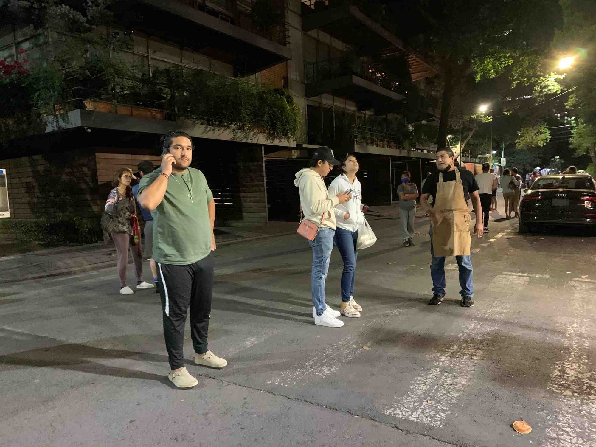 Les gens attendent devant chez eux apres qu'un tremblement a ete ressenti a mexico