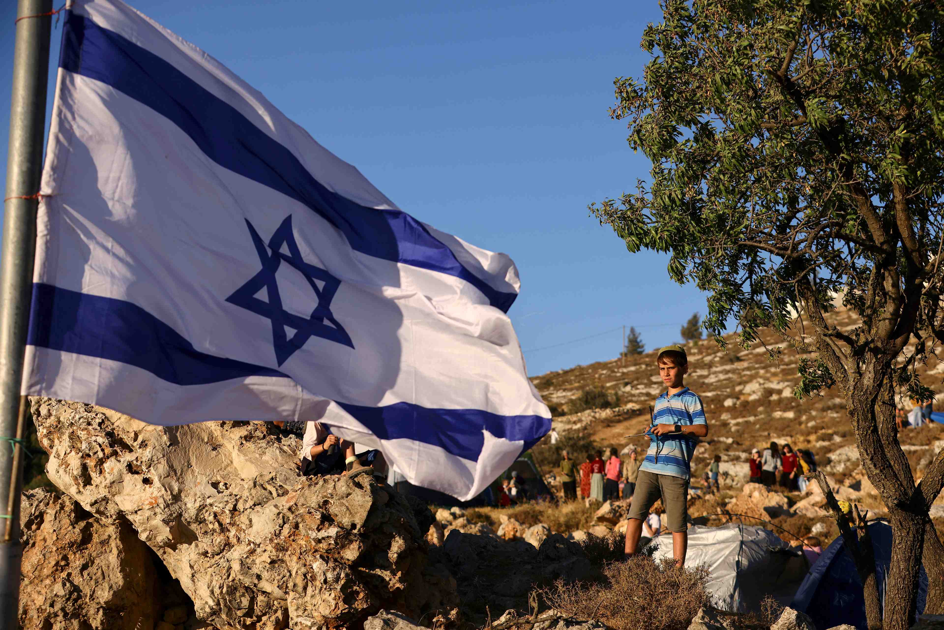 Un garcon et un drapeau israelien pres de kiryat arba, une colonie juive pres de la cisjordanie occupee par israel