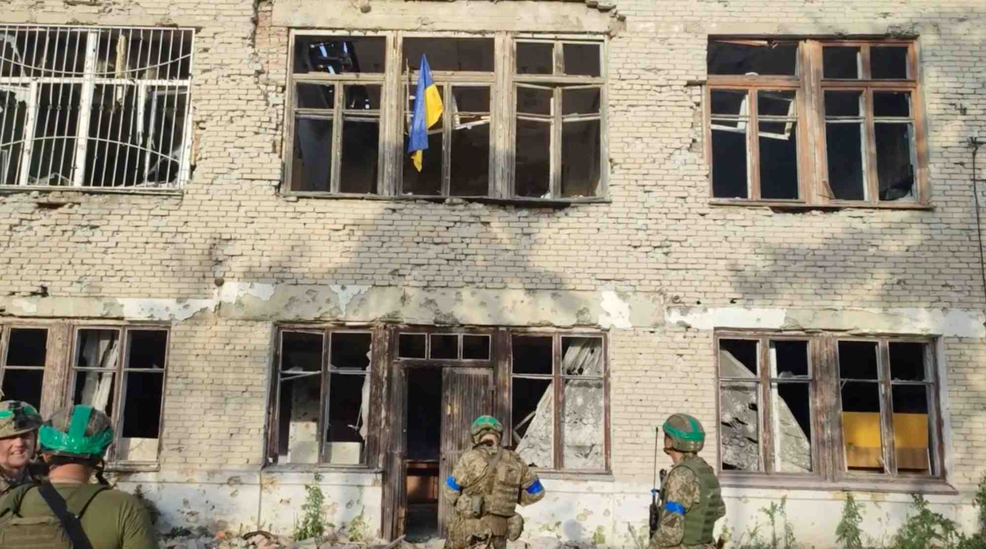 Des soldats ukrainiens devant un batiment portant le drapeau ukrainien, lors d'une contre-offensive, a blahodatne, dans la region de donetsk, en ukraine.