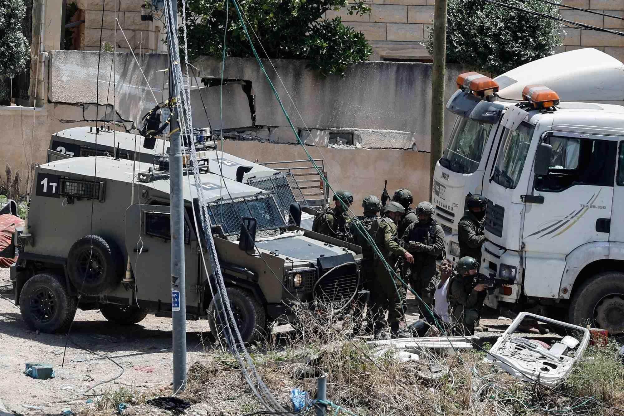 De nombreux soldats israeliens arretent un homme palestinien lors d'un raid en cisjordanie occupee
