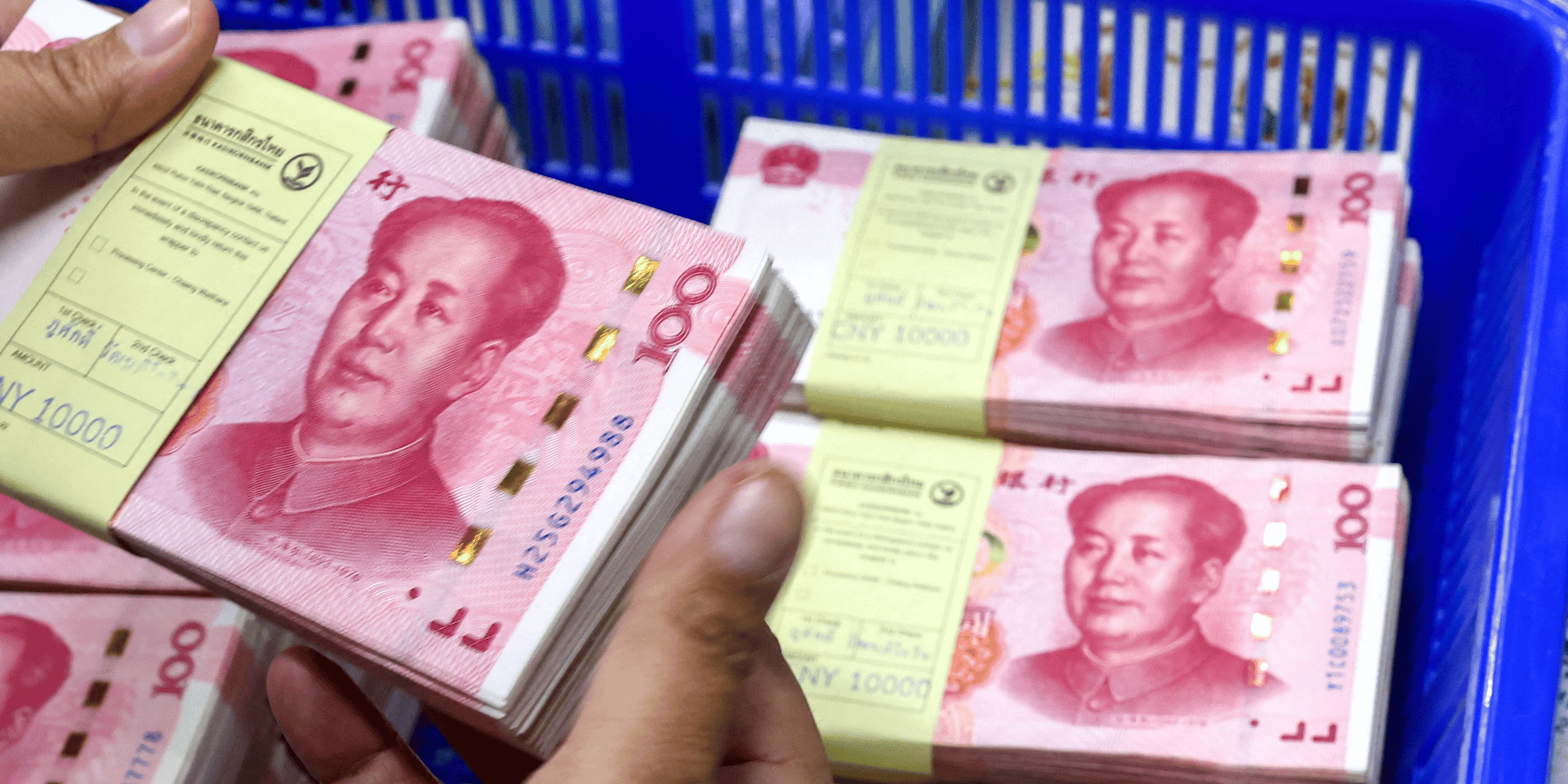 Un employe de banque compte les billets en renminbi (rmb) ou yuan de la chine a cote des billets en dollars americains dans une kasikornbank a bangkok