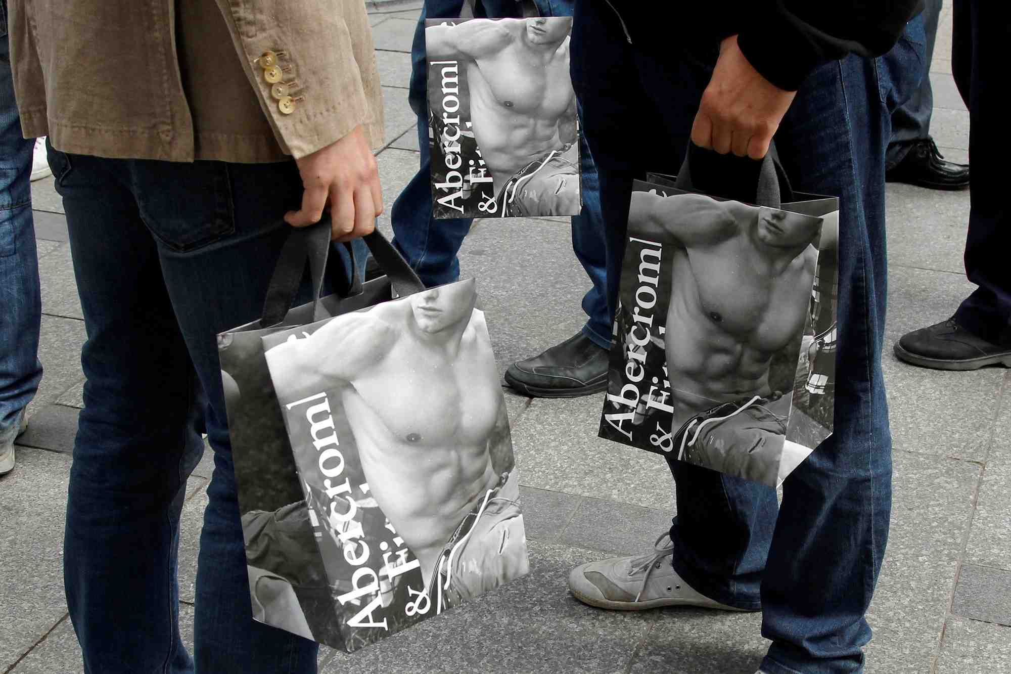 Des acheteurs tiennent des sacs d'abercrombie & fitch a l'exterieur du magasin parisien de la societe sur les champs elysees