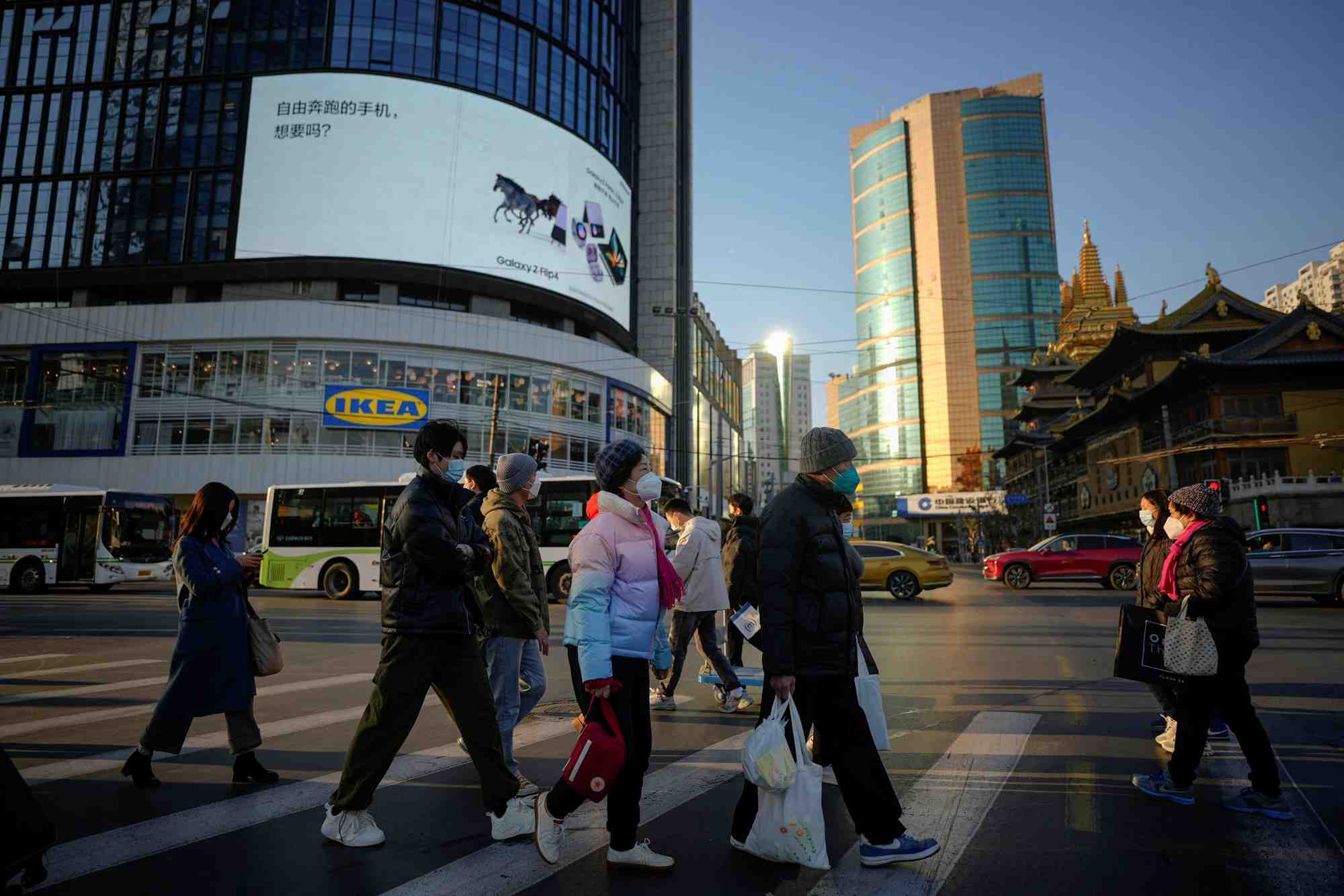 Des personnes portant des masques de protection traversent une rue a shanghai