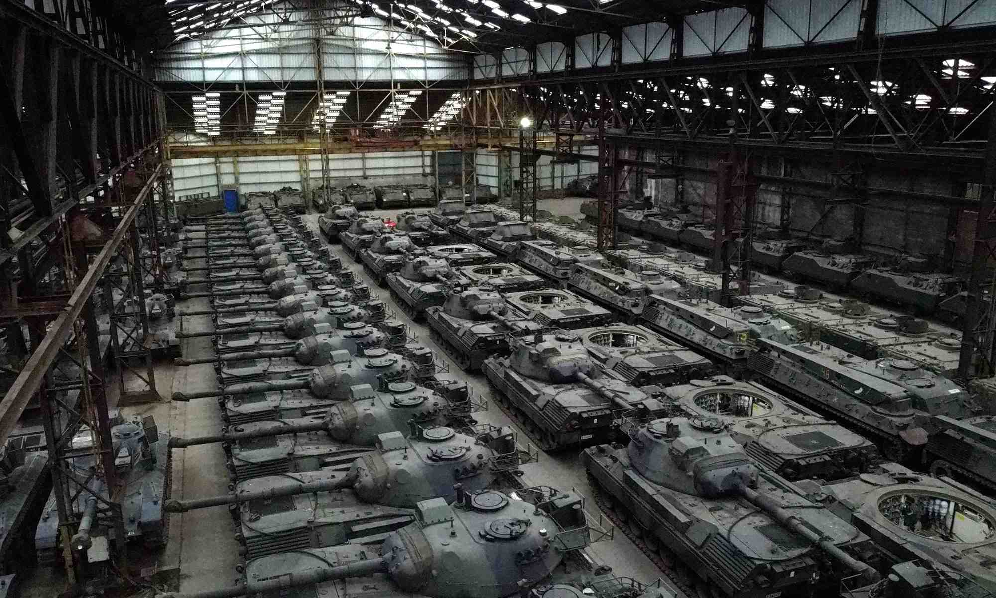 Des dizaines de chars leopard 1 de fabrication allemande et d'autres vehicules blindes sont vus dans un hangar a tournais