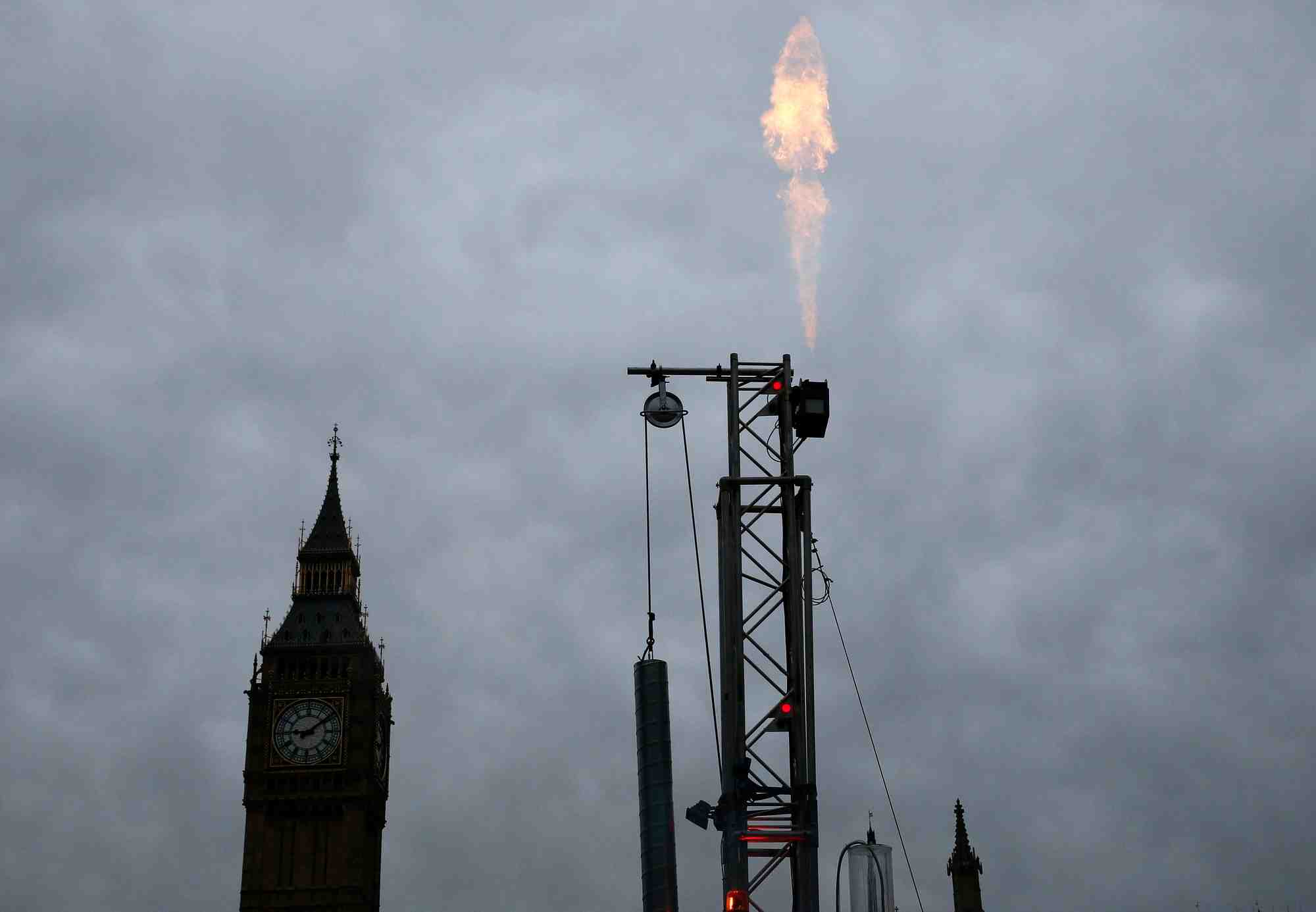 Du gaz brule d'une plate-forme de fracturation lors d'une manifestation de greenpeace devant le parlement a londres
