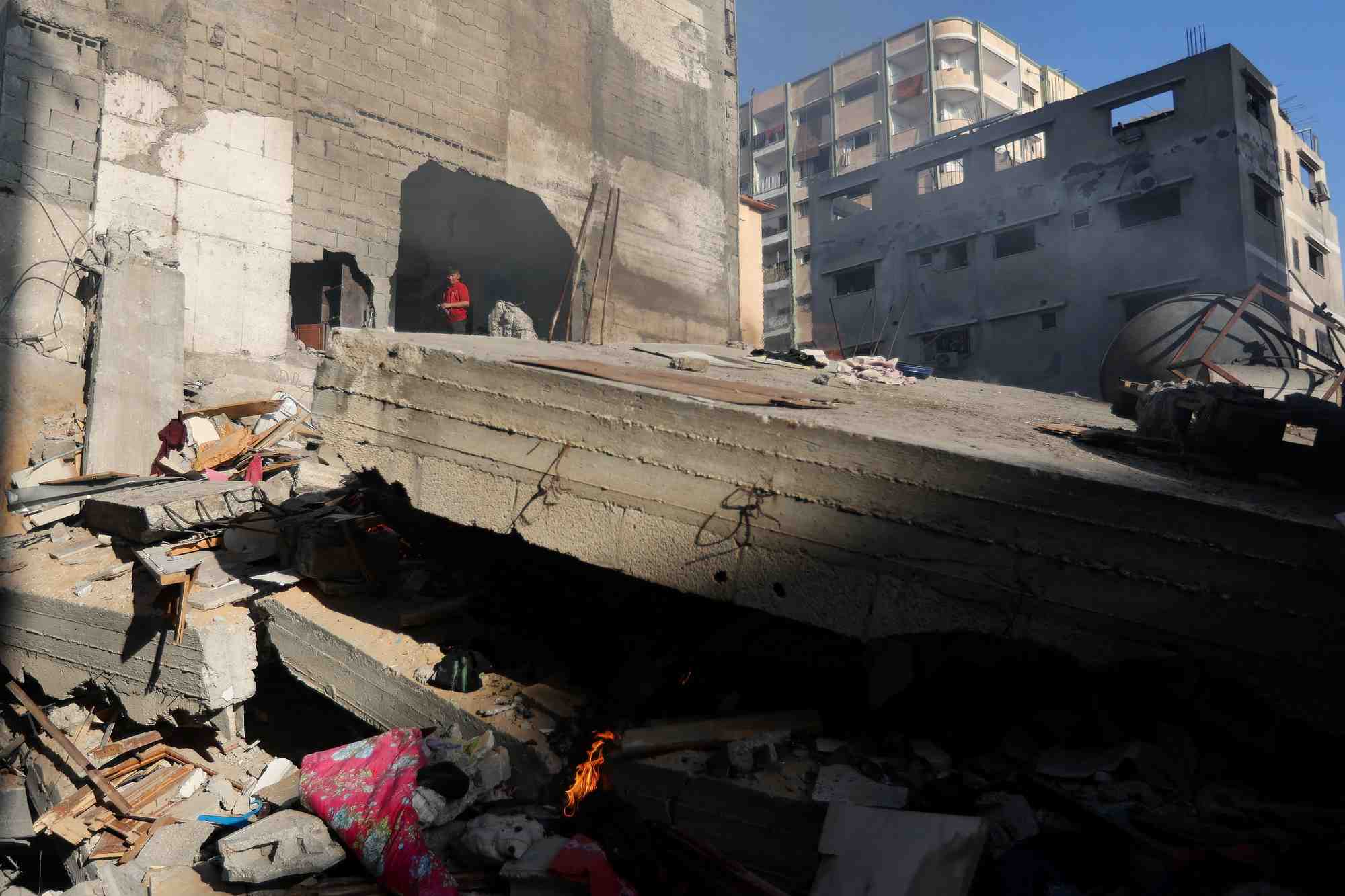 Photo des palestiniens qui inspectent une maison detruite lors d'une frappe israelienne, a khan younis
