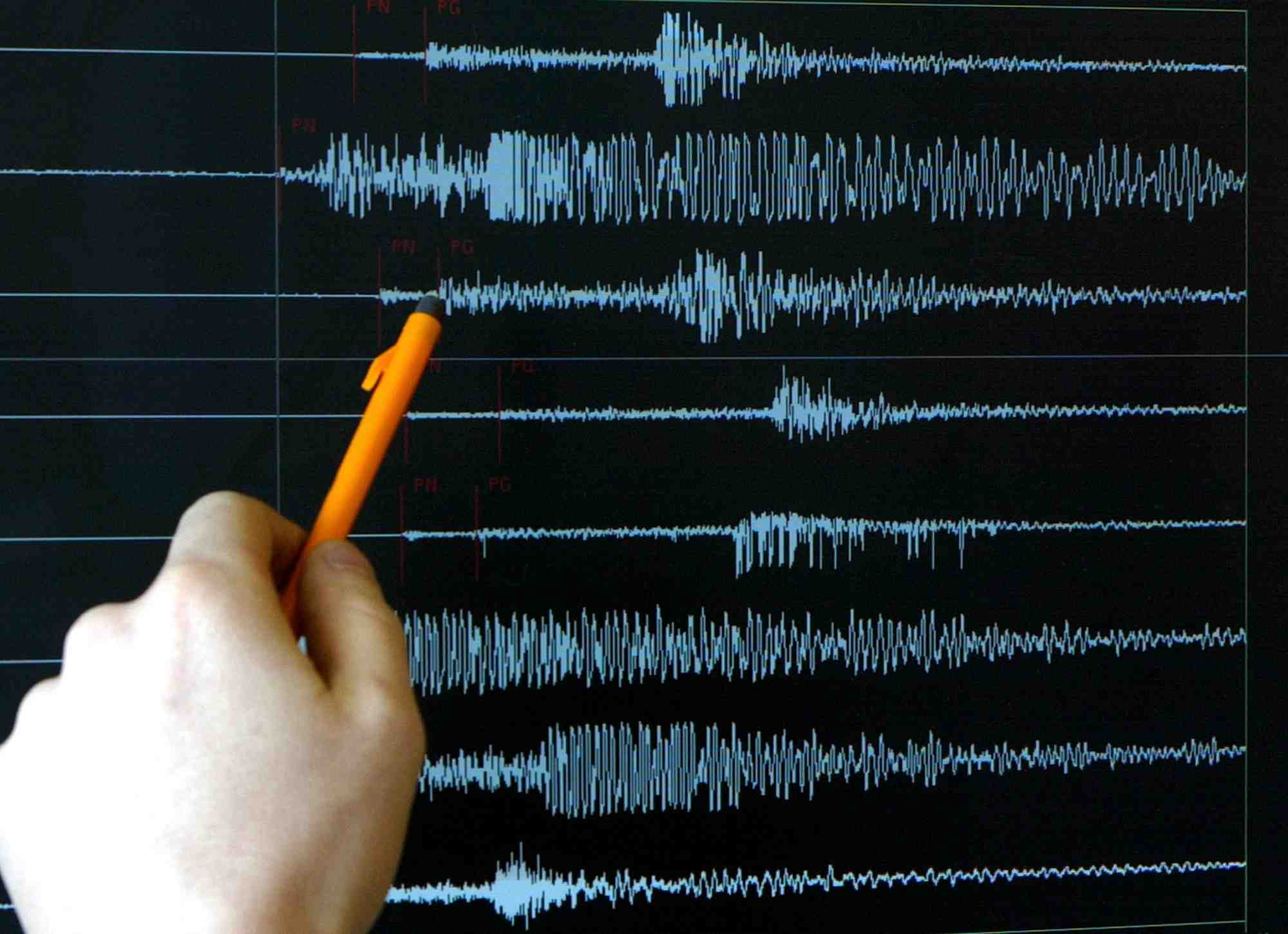 Un technicien pointe un graphique apres un tremblement de terre