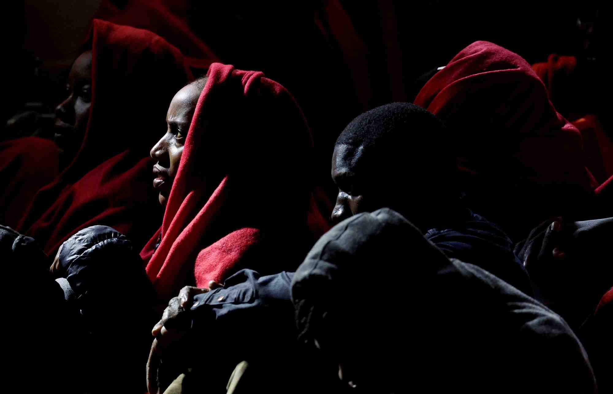 Des migrants attendent avant de debarquer d'un navire des gardes-cotes espagnols dans le port d'arguineguin sur l'ile de grande canarie