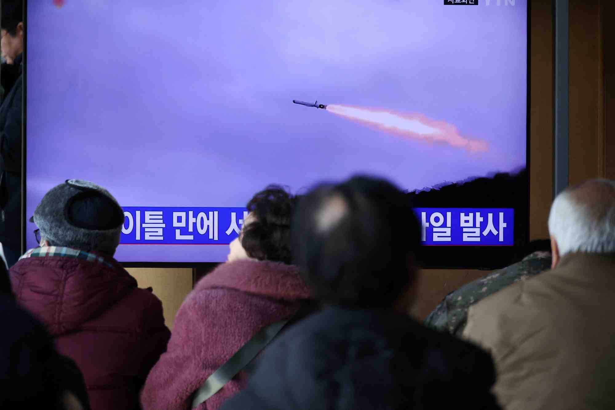 Des personnes regardent un reportage sur le tir de missiles par la coree du nord en janvier 2024