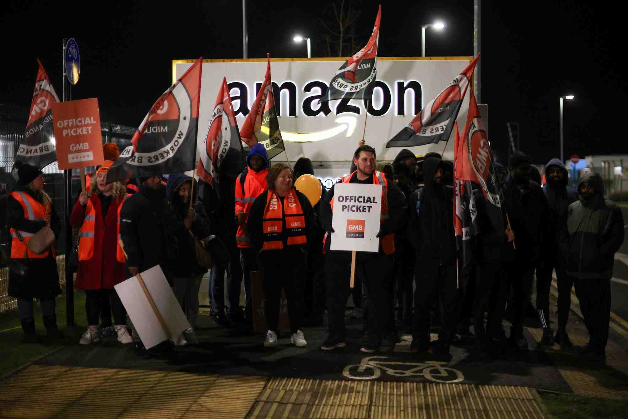 Des personnes brandissent des pancartes lors d'une mobilisation devant l'entrepot d'amazon dans la ville anglaise de coventry a l'occasion du black friday