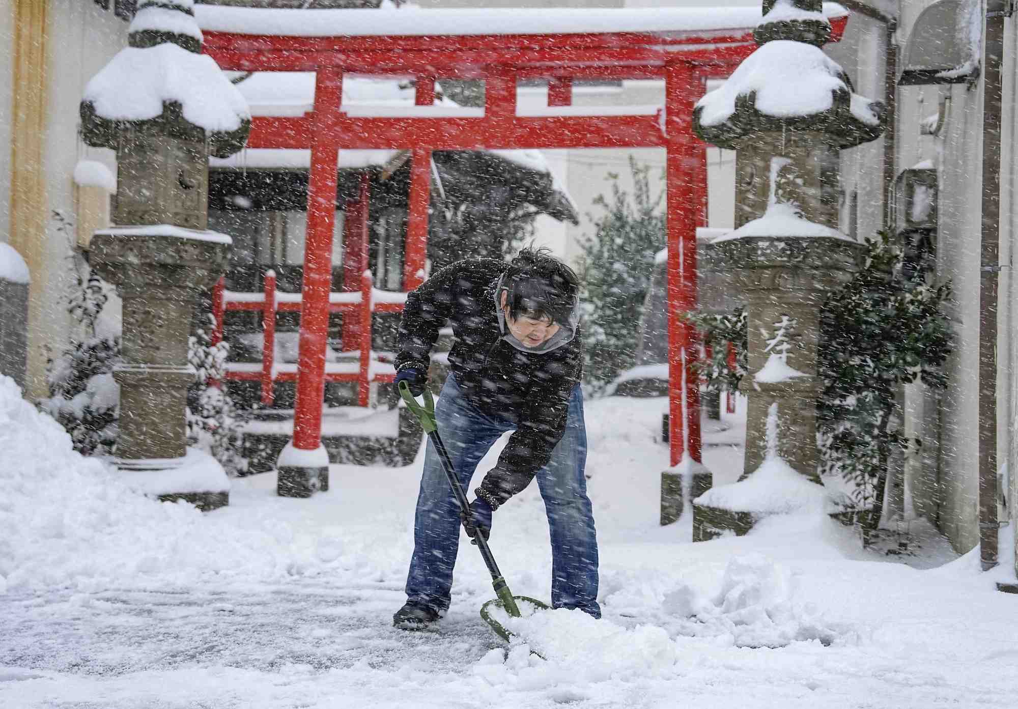 Un homme deblaie la neige devant un sanctuaire a tottori