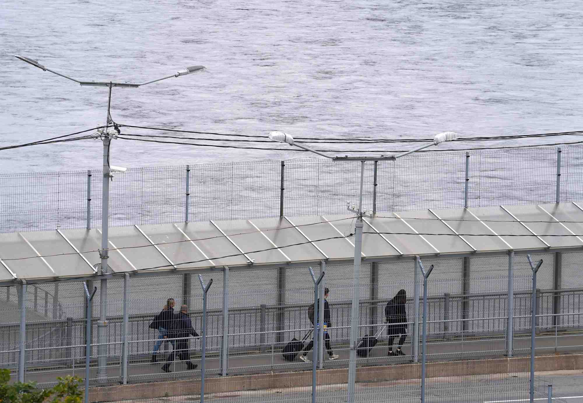 Des gens traversent un pont au point de passage frontalier avec la russie a narva, en estonie
