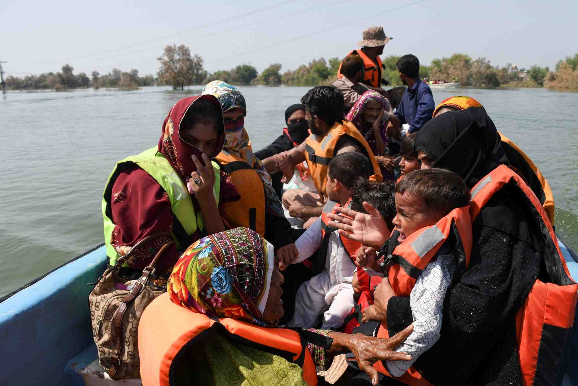 Des gens assis dans un bateau, suite aux pluies et aux inondations dans le village d'arazi, au pakistan