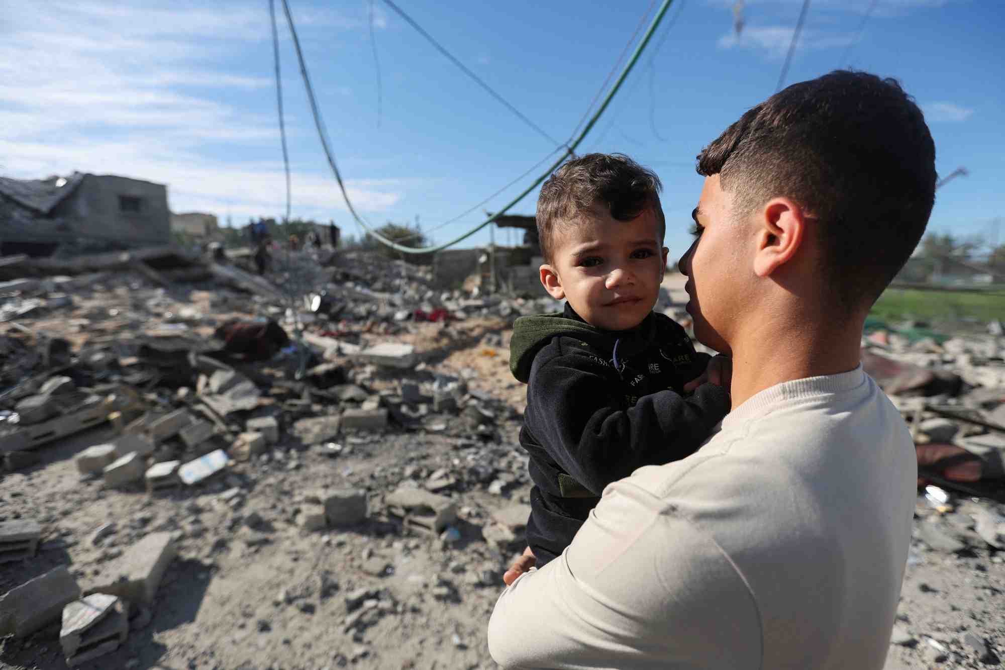 Photo d'un palestinien qui tient un enfant dans ses bras