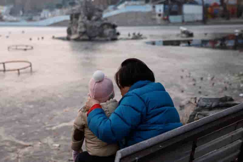 Une femme et un enfant assis dans un parc a pekin