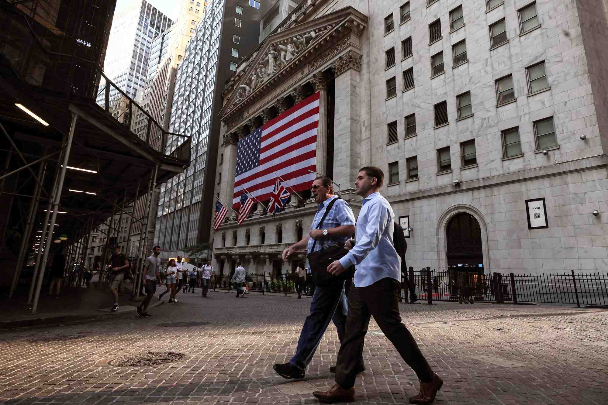 Des personnes marchent sur wall street devant la bourse de new york (nyse)