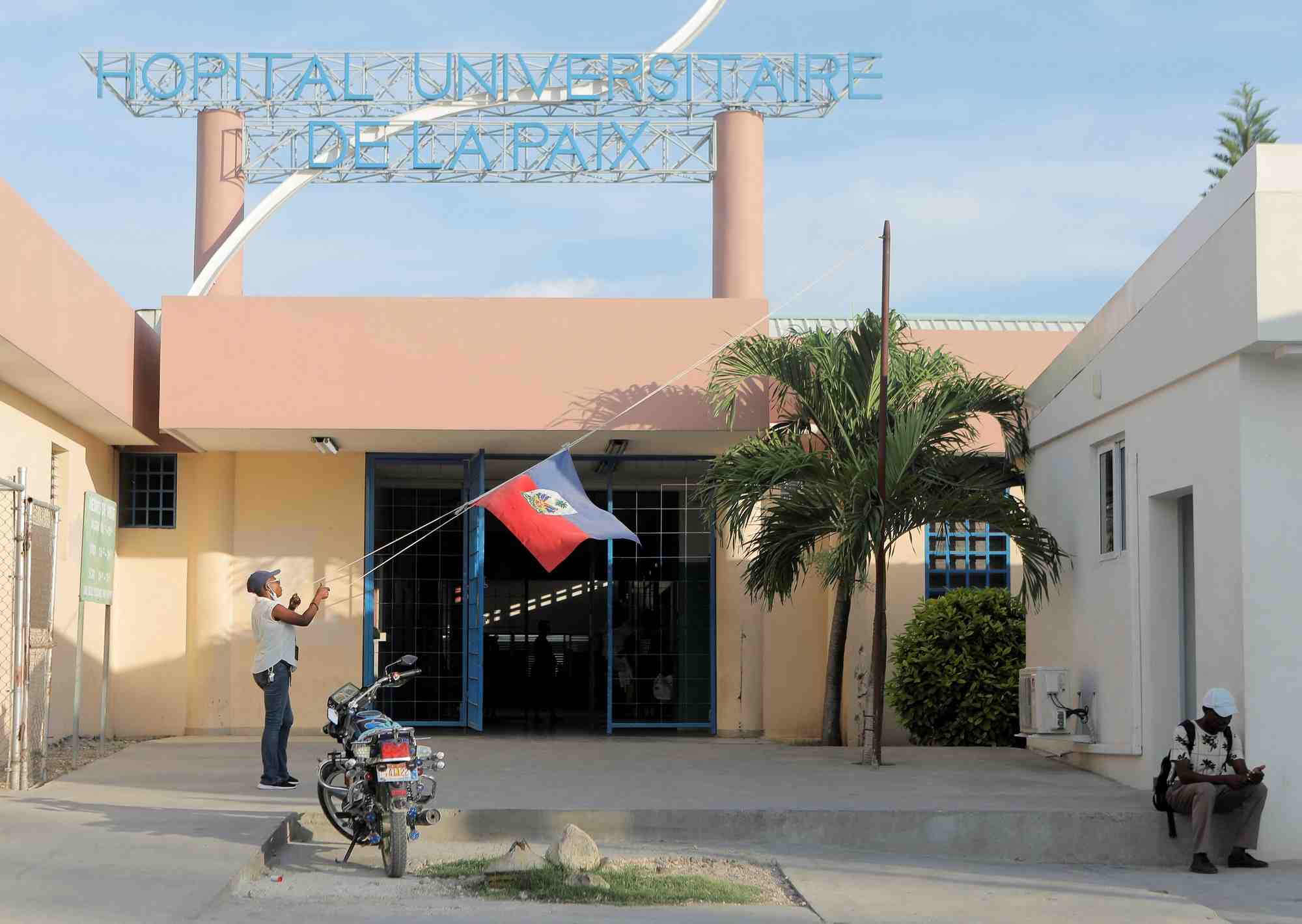 Une femme abaisse le drapeau d'haiti dans un hopital de port-au-prince