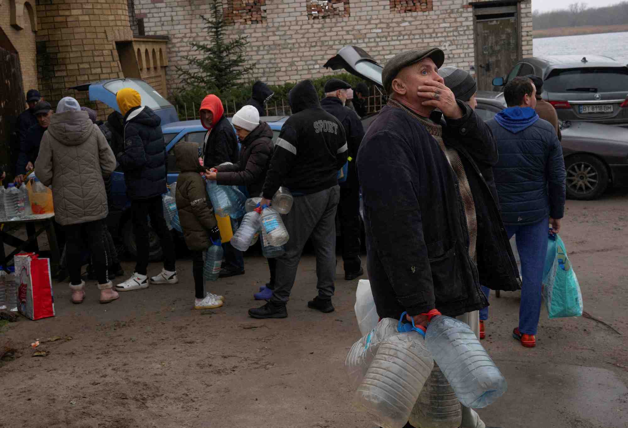 Des personnes remplissent des bouteilles d'eau pres du fleuve dniepr apres la retraite militaire russe de kherson