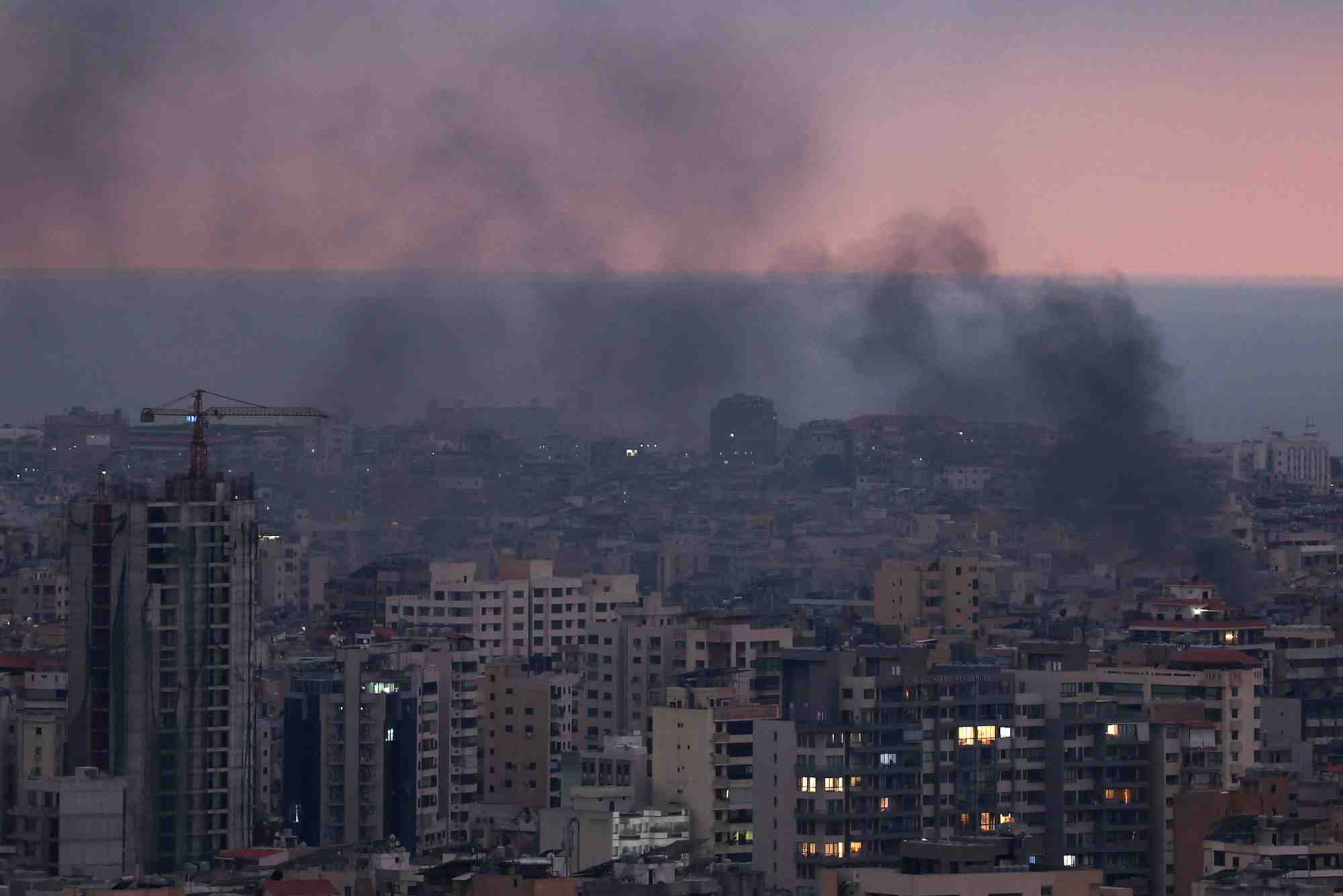 De la fumee s'eleve dans la banlieue sud de beyrouth au coucher du soleil, apres des frappes aeriennes israeliennes, dans le cadre des hostilites entre le hezbollah et les forces israeliennes, vue de sin el fil, liban.