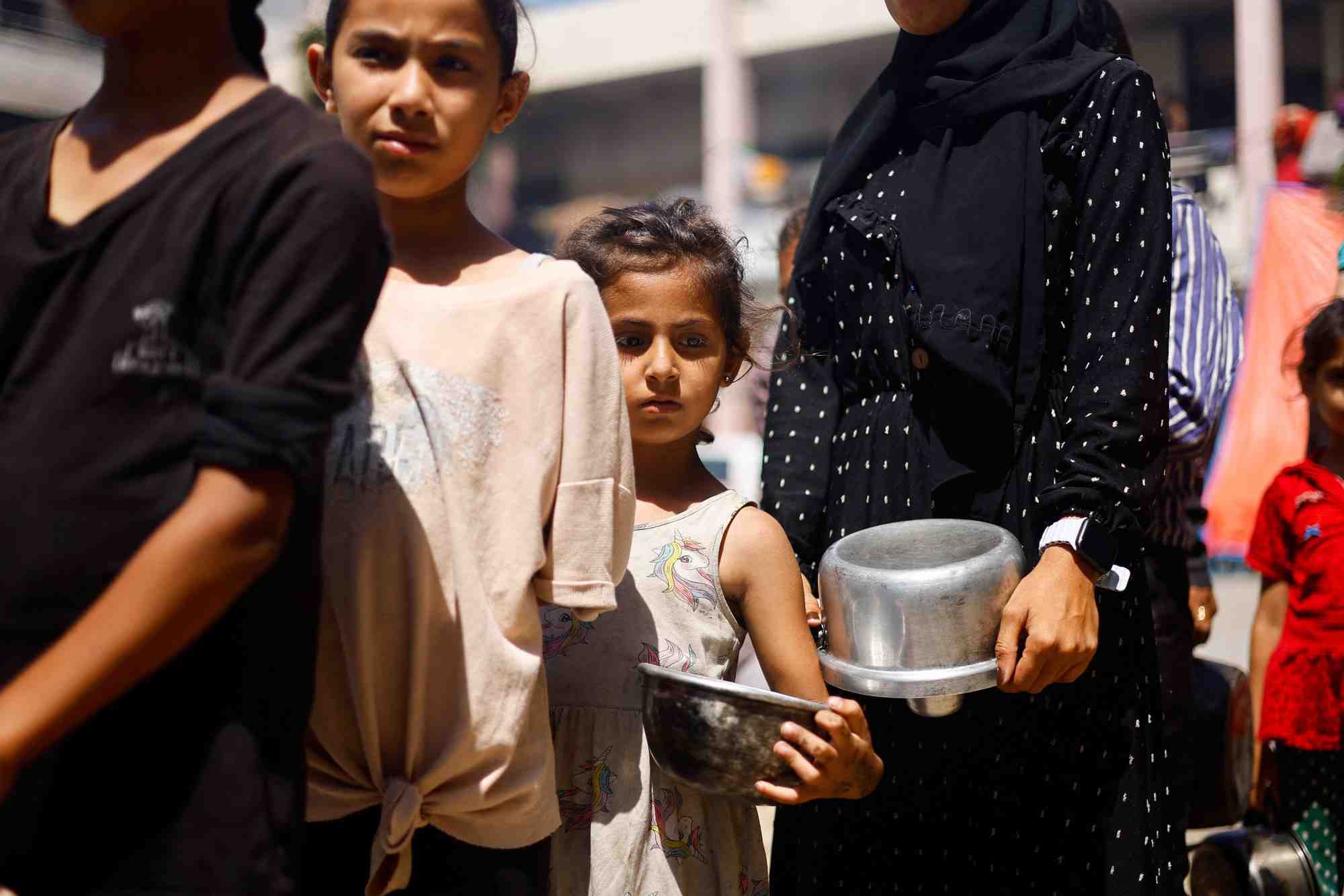 Des palestiniens se rassemblent pour recevoir de la nourriture preparee par une cuisine caritative, dans un contexte de penurie alimentaire, alors que le conflit entre israel et le hamas se poursuit, a khan younis, dans le sud de la bande de gaza