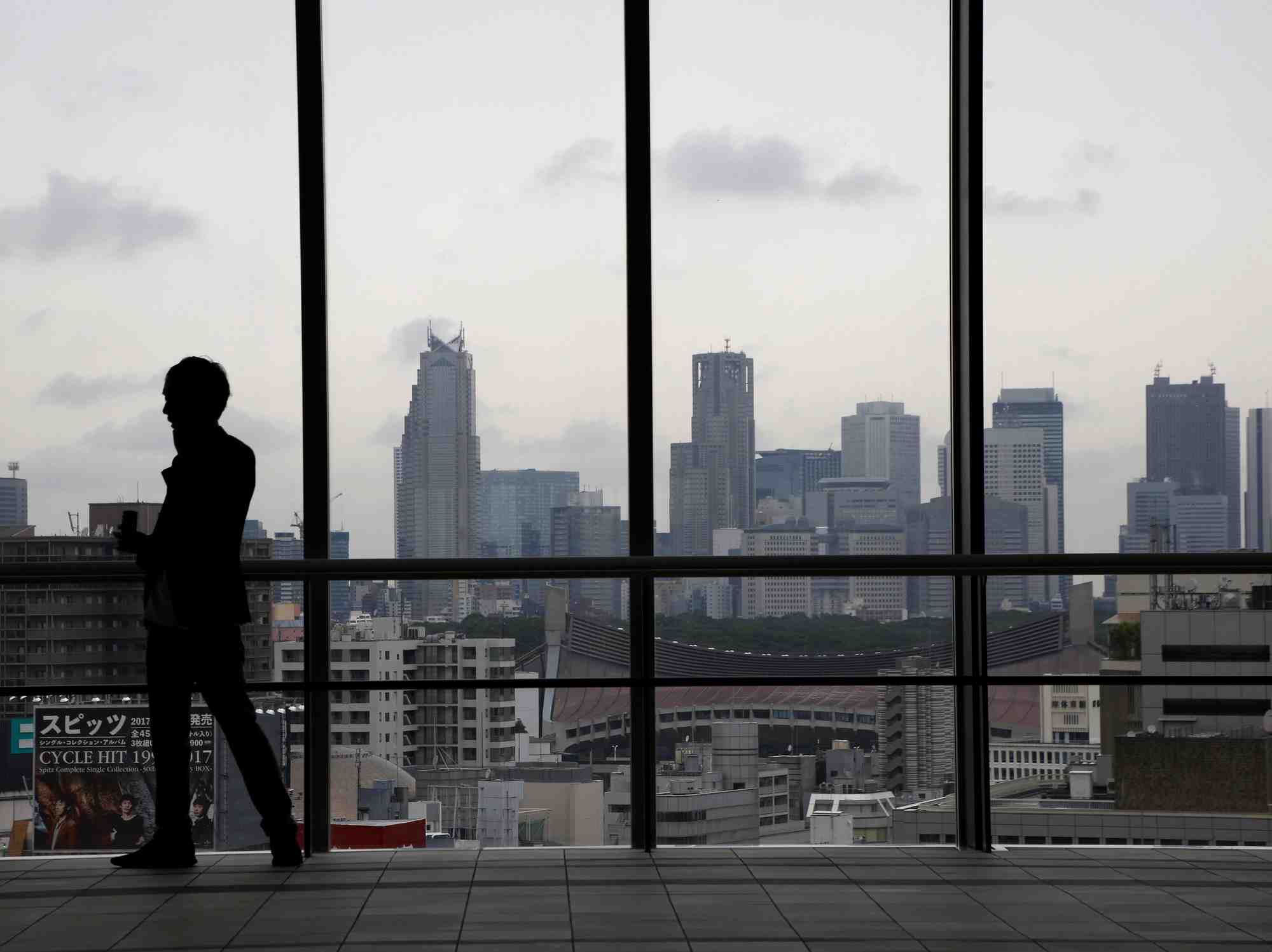 La silhouette d'un homme devant les gratte-ciel de tokyo