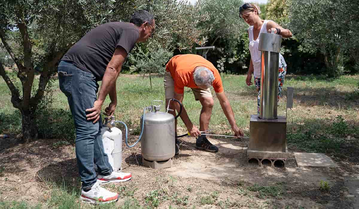 Frédéric Jouffret (au centre) effectue une démonstration du générateur pour l'ensemencement des nuages dans le jardin de Jean-Claude Micol (à gauche) en présence de Sandra Scavennec de Previgrêle, à Carpentras, juillet 2024.