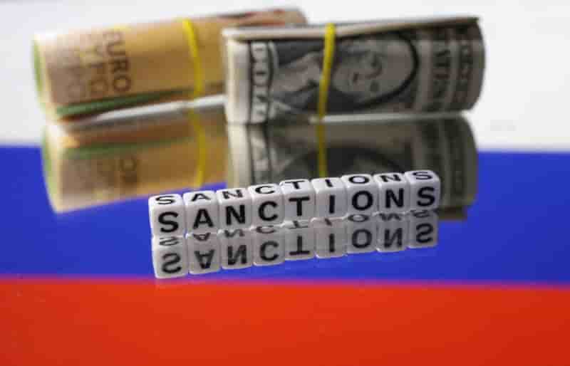 Billets de banque en euros et en dollars et mots "sanctions" sur le drapeau russe