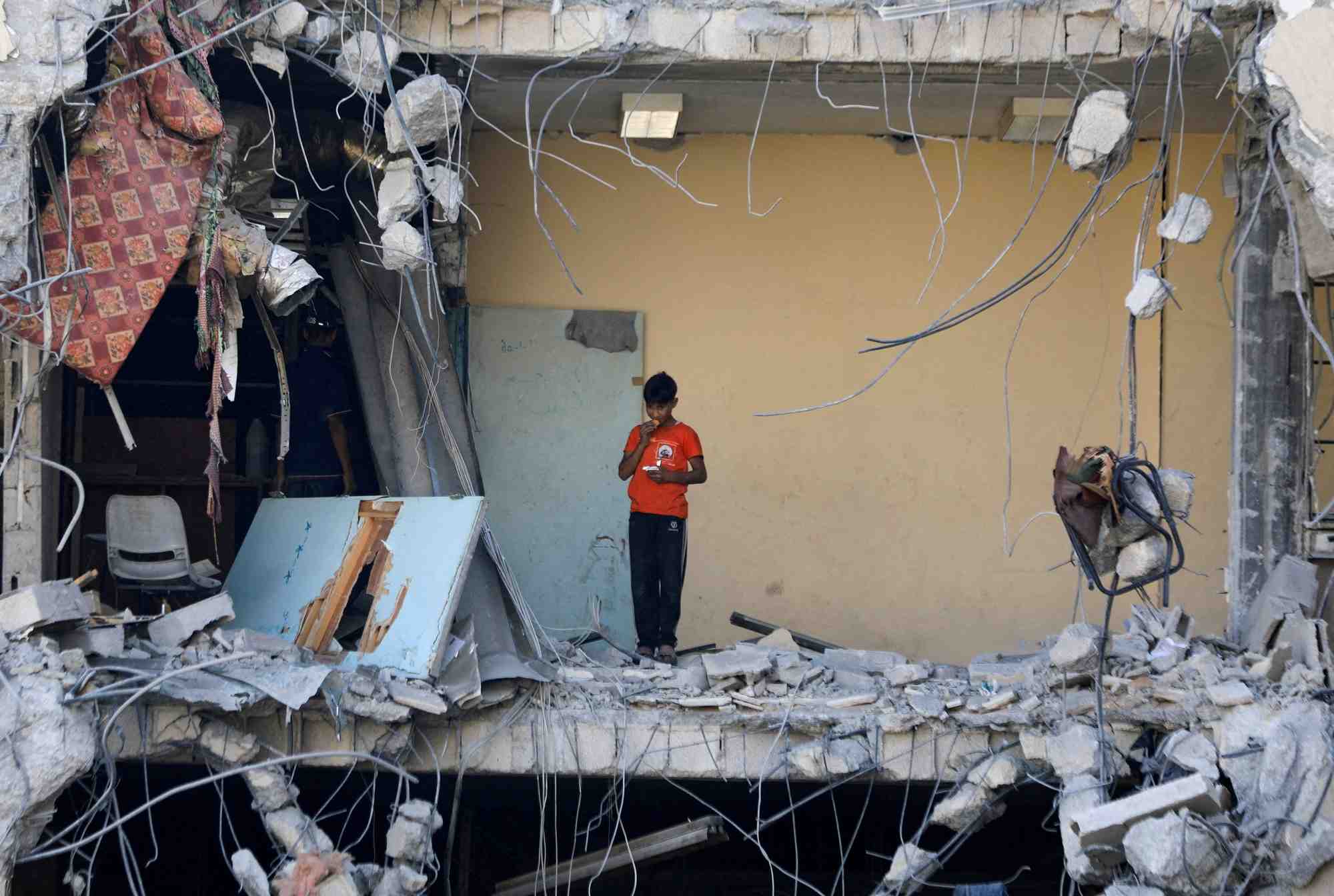 Un garcon palestinien se tient parmi les decombres, en pleine conflit entre israel et le hamas, a gaza