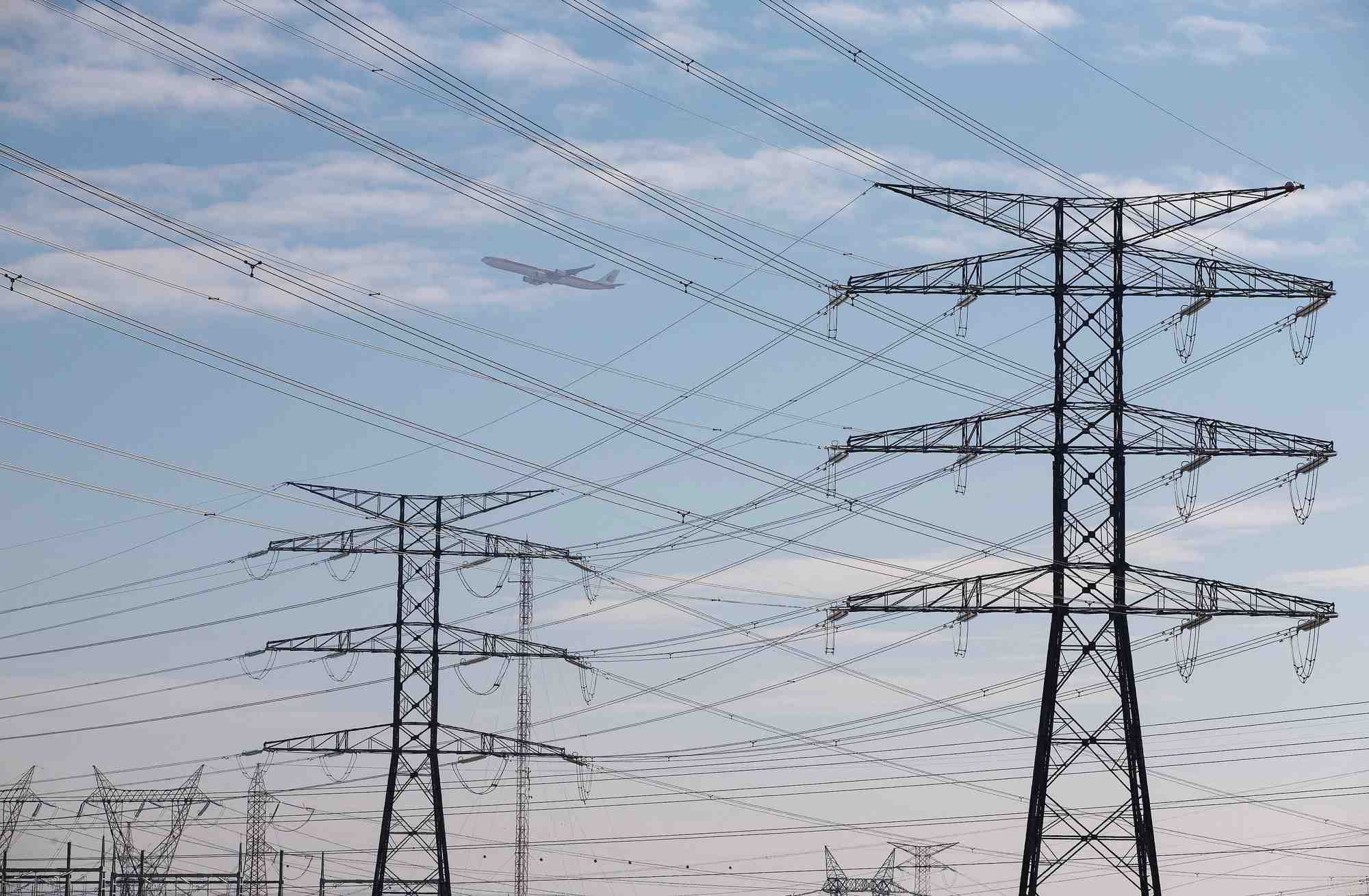 An iberia jet flies over power lines outside madrid