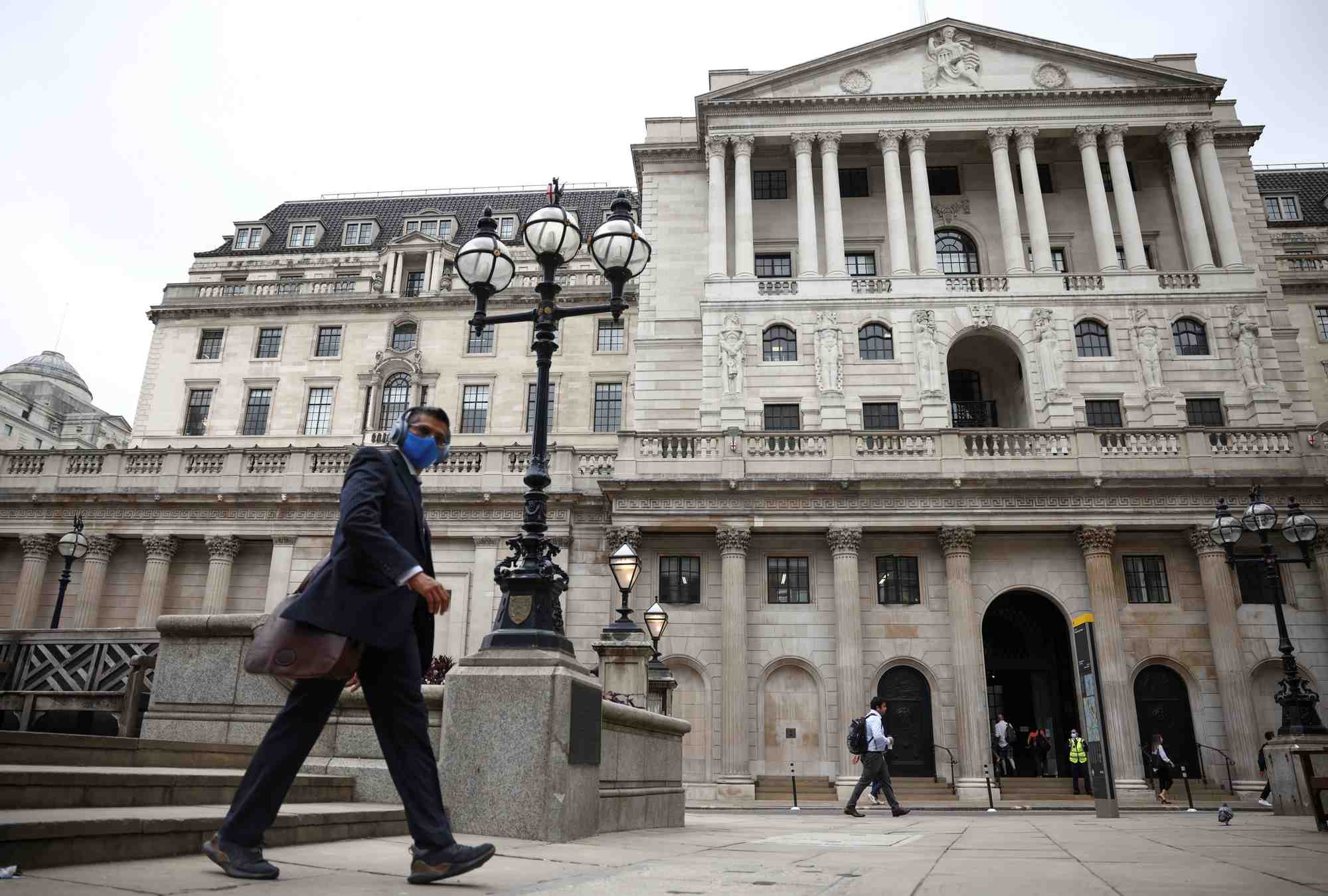 Un passant devant la banque d'angleterre dans le quartier financier de la city de londres