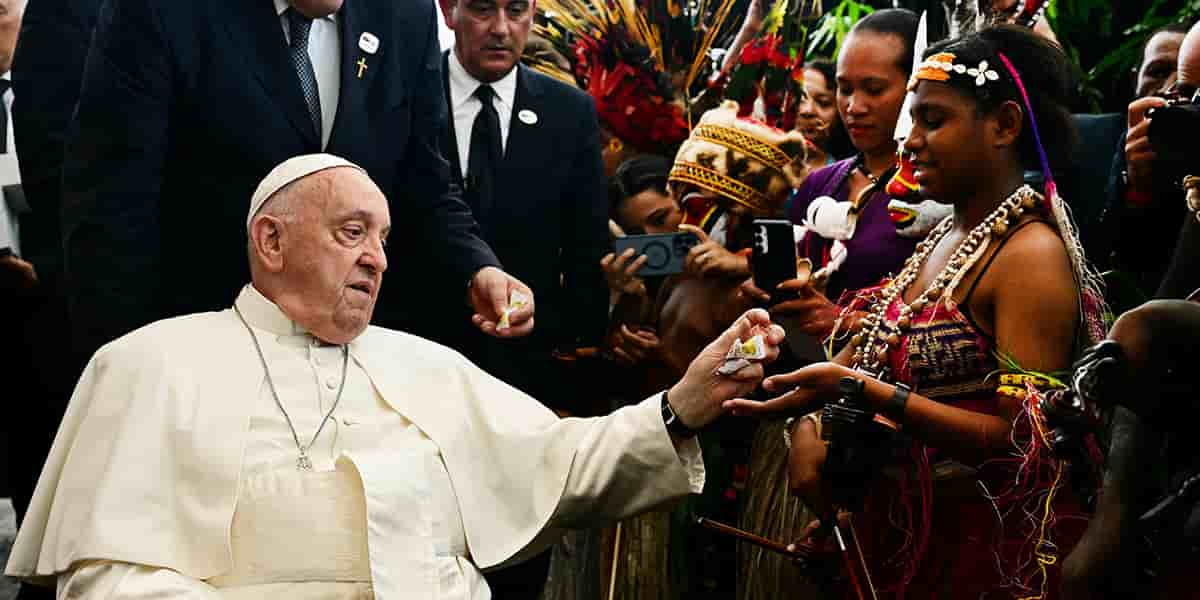 Le pape donnant des confiseries à des musiciens lors de la cérémonie d’accueil, hier à Port Moresby (Papouasie-Nouvelle-Guinée).