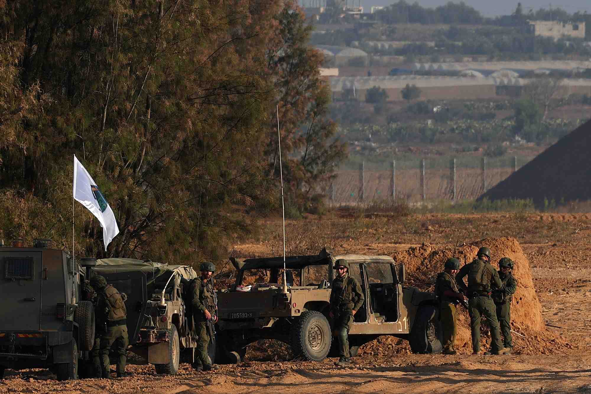 Des soldats israeliens se tiennent a cote de vehicules militaires pres de la frontiere entre israel et la bande de gaza, dans le cadre du conflit entre israel et le hamas