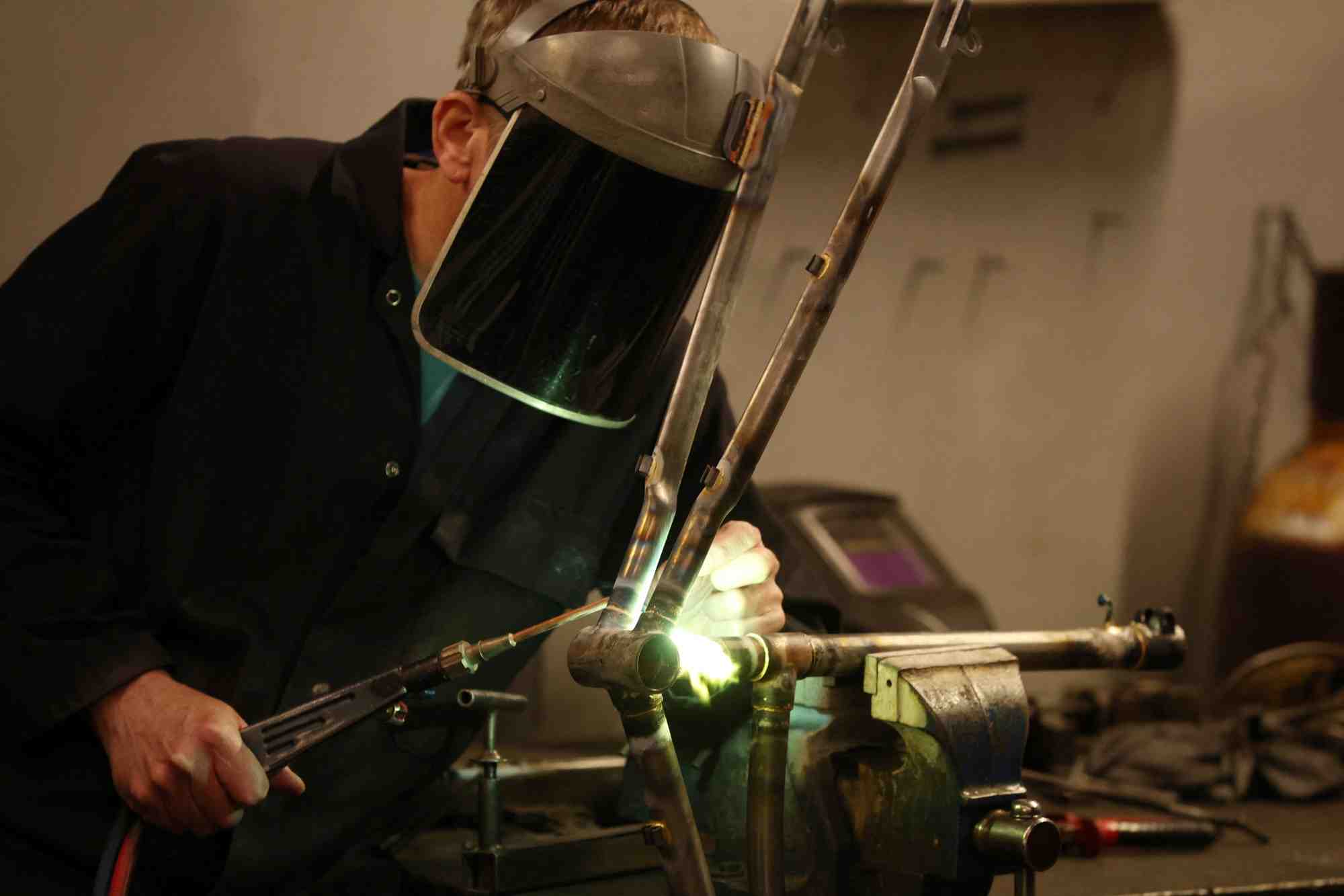 Un ouvrier assemble un cadre de velo dans une usine de pashley