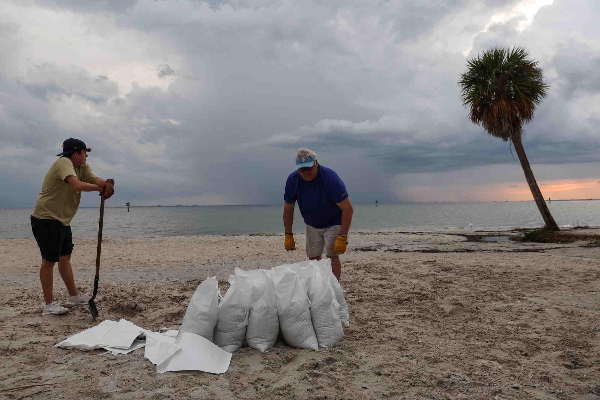 Rich reynolds et son fils john remplissent des sacs de sable alors que l'ouragan ian se dirige vers la floride