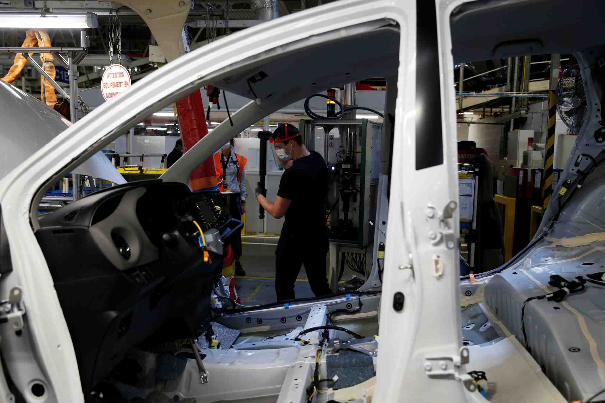 Des employes travaillent sur la chaine de montage d'automobiles dans l'usine toyota motor