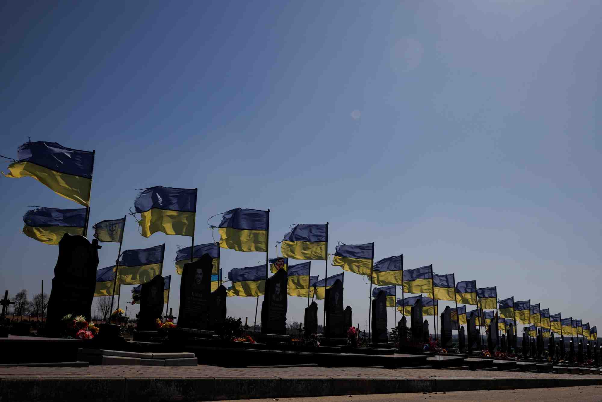 Des drapeaux nationaux ukrainiens flottent sur les tombes de soldats morts au combat