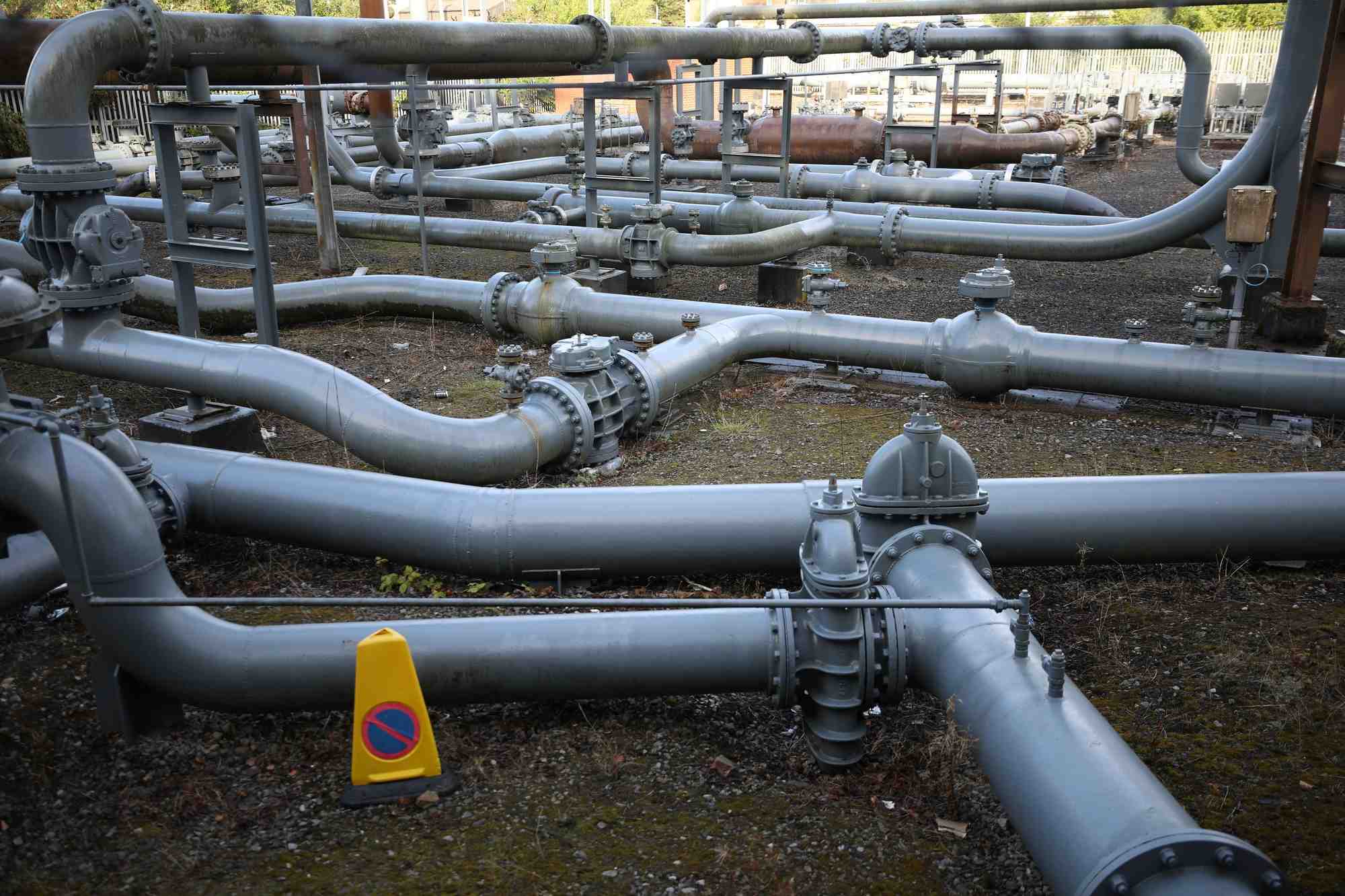 Photo des sections de gazoduc a cote d'un reservoir de gaz desaffecte a manchester