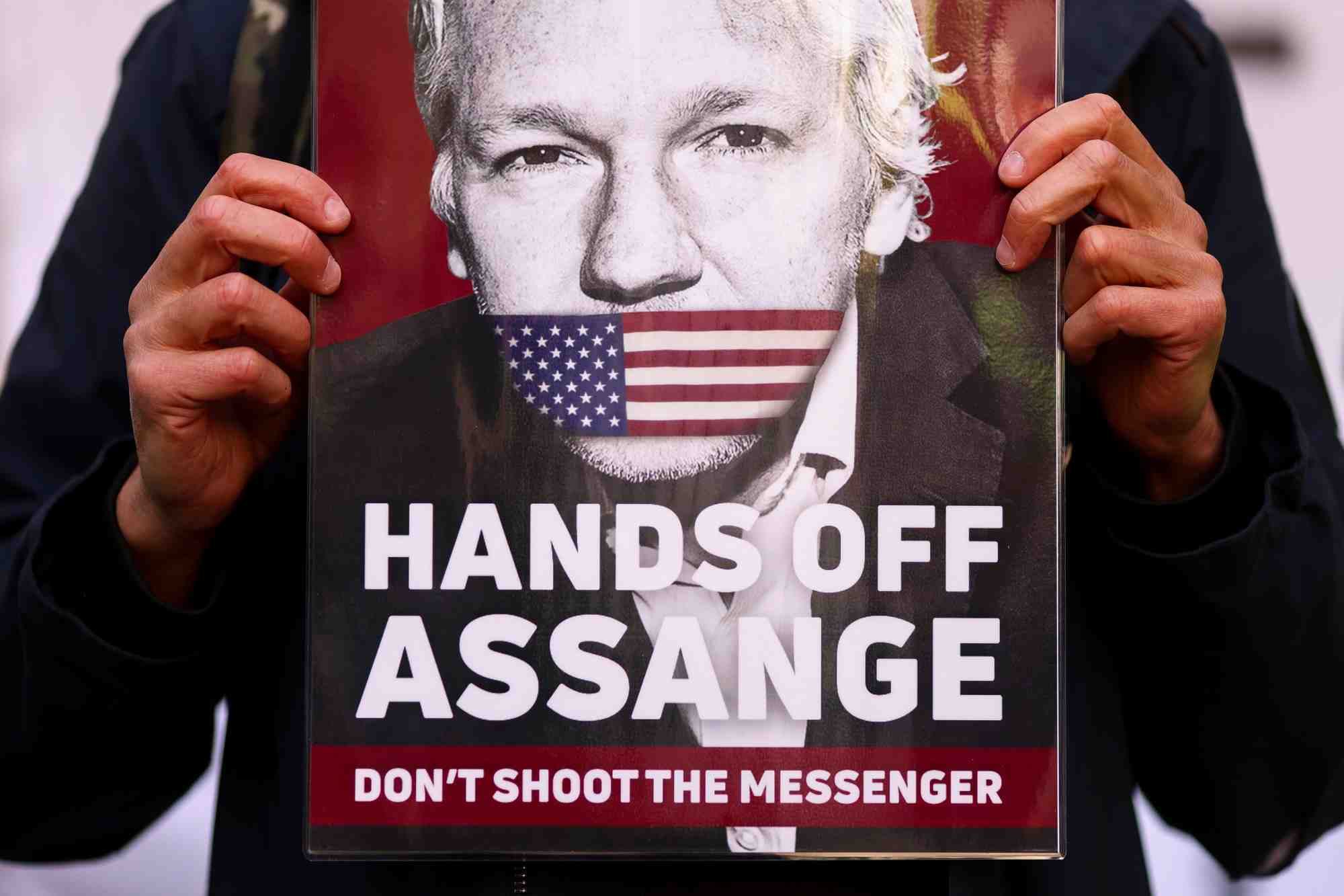 Un soutien de julian assange montre une pancarte avec son visage devant le tribunal de westminster a londres