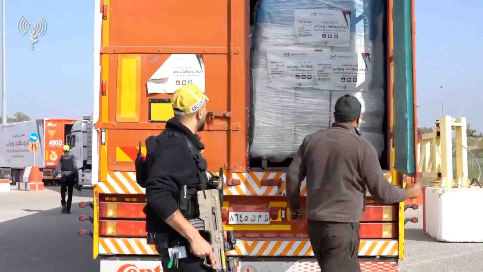 Des camions d'aide humanitaire font la queue pour etre inspectes au passage de kerem shalom