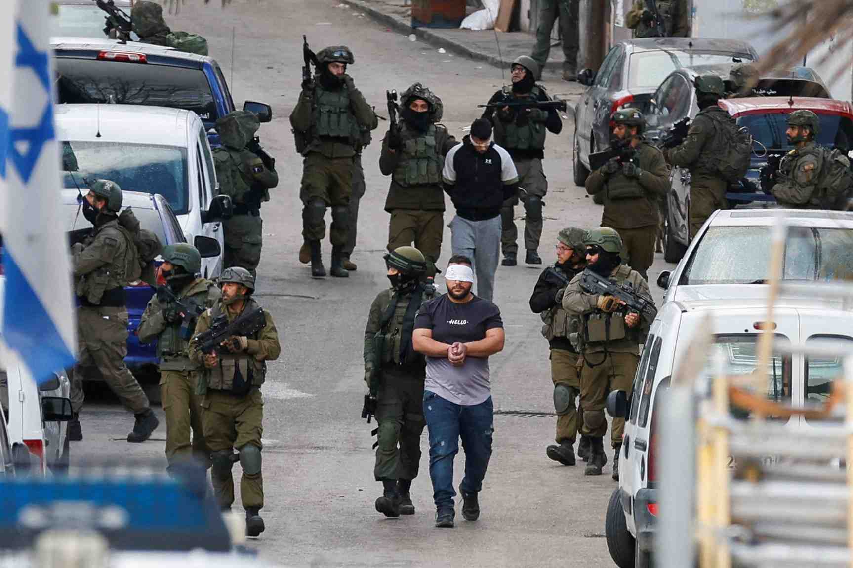 Des soldats israeliens arrpetes des hommes palestiniens a ramallah, en cisjordanie