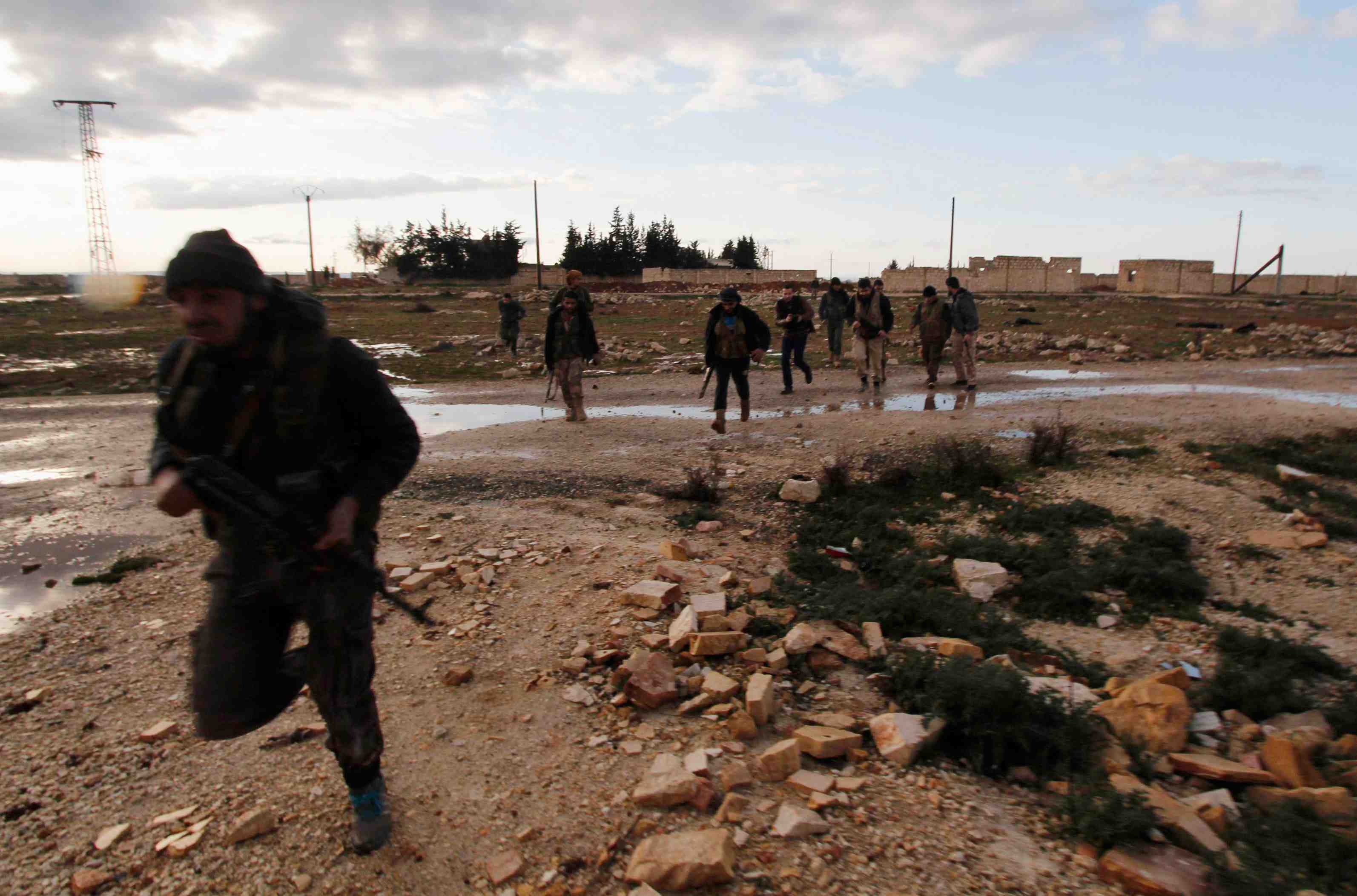 Rebel fighters of al-jabha al-shamiya carry their weapons as they run in al-mallah area, after what they said were heavy clashes with forces loyal to syria's president bashar al-assad, north of aleppo