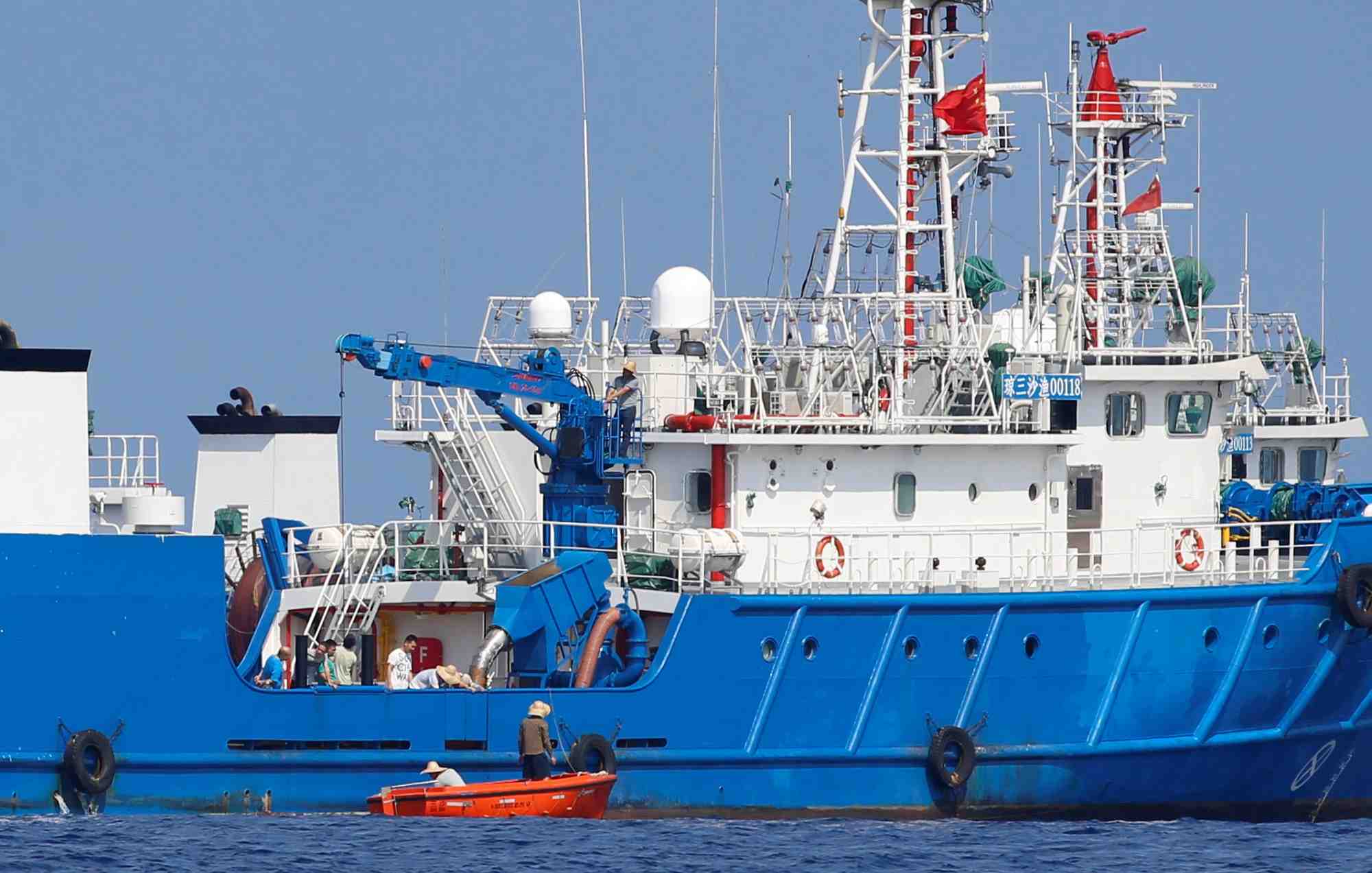 Chinese fishermen are pictured at a ship in the disputed scarborough shoal