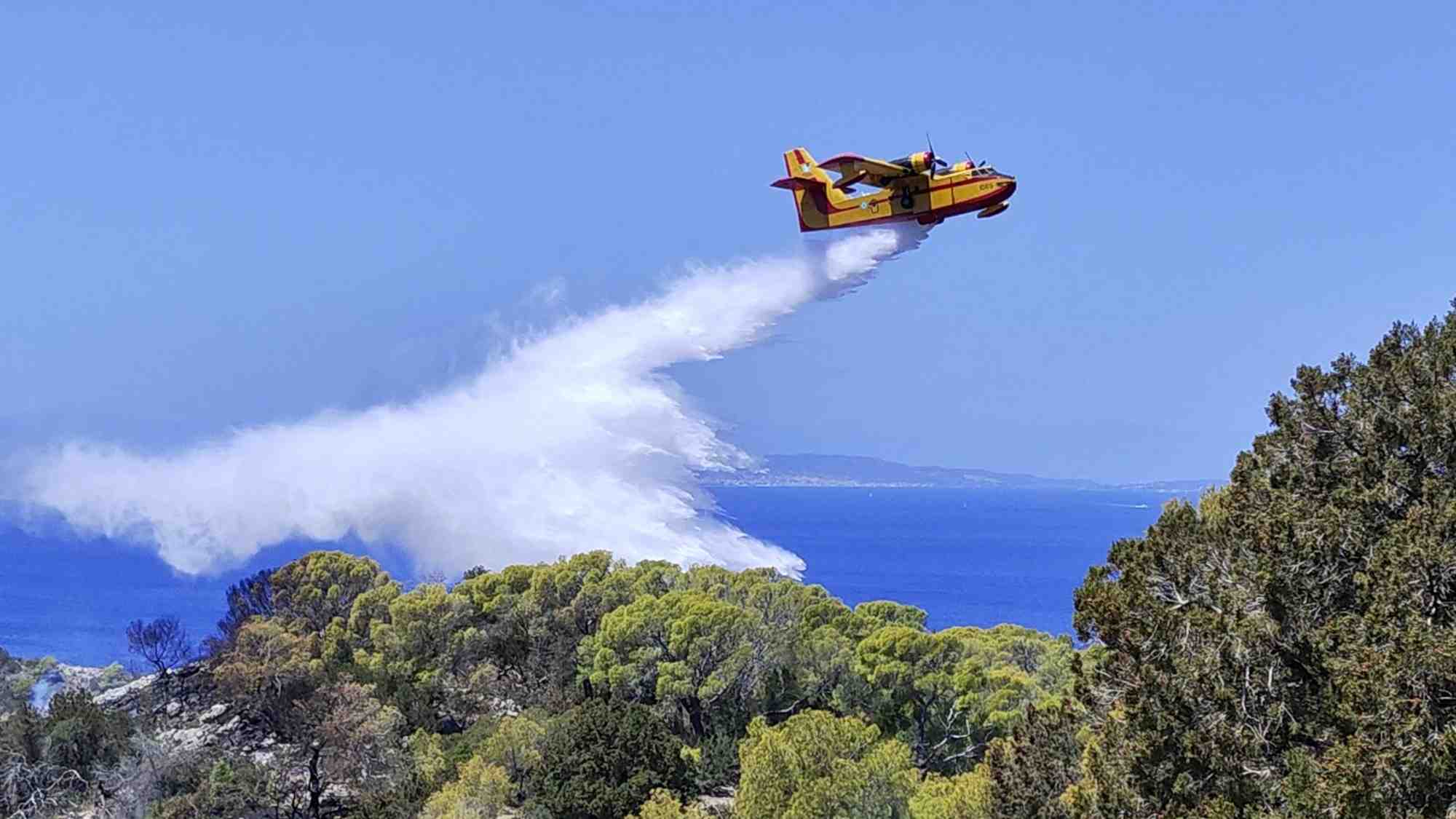 Un avion de lutte contre les incendies largue de l'eau sur une zone touchee par un feu de foret sur l'ile d'hydra