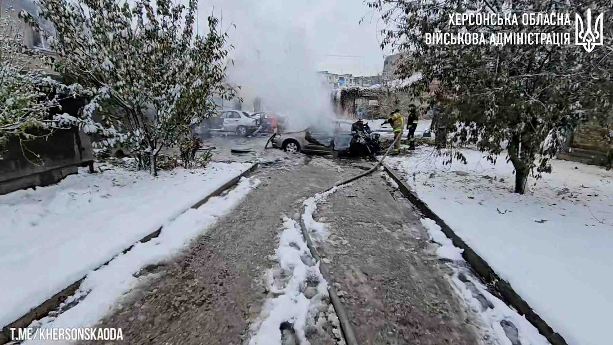 Les premiers intervenants travaillent pres de voitures incendiees apres une frappe d'artillerie russe meurtriere a kherson, en ukraine
