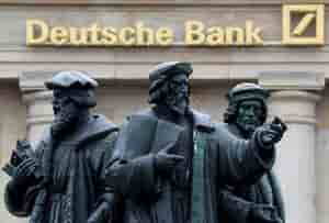 A statue is pictured next to the logo of germany's deutsche bank in frankfurt