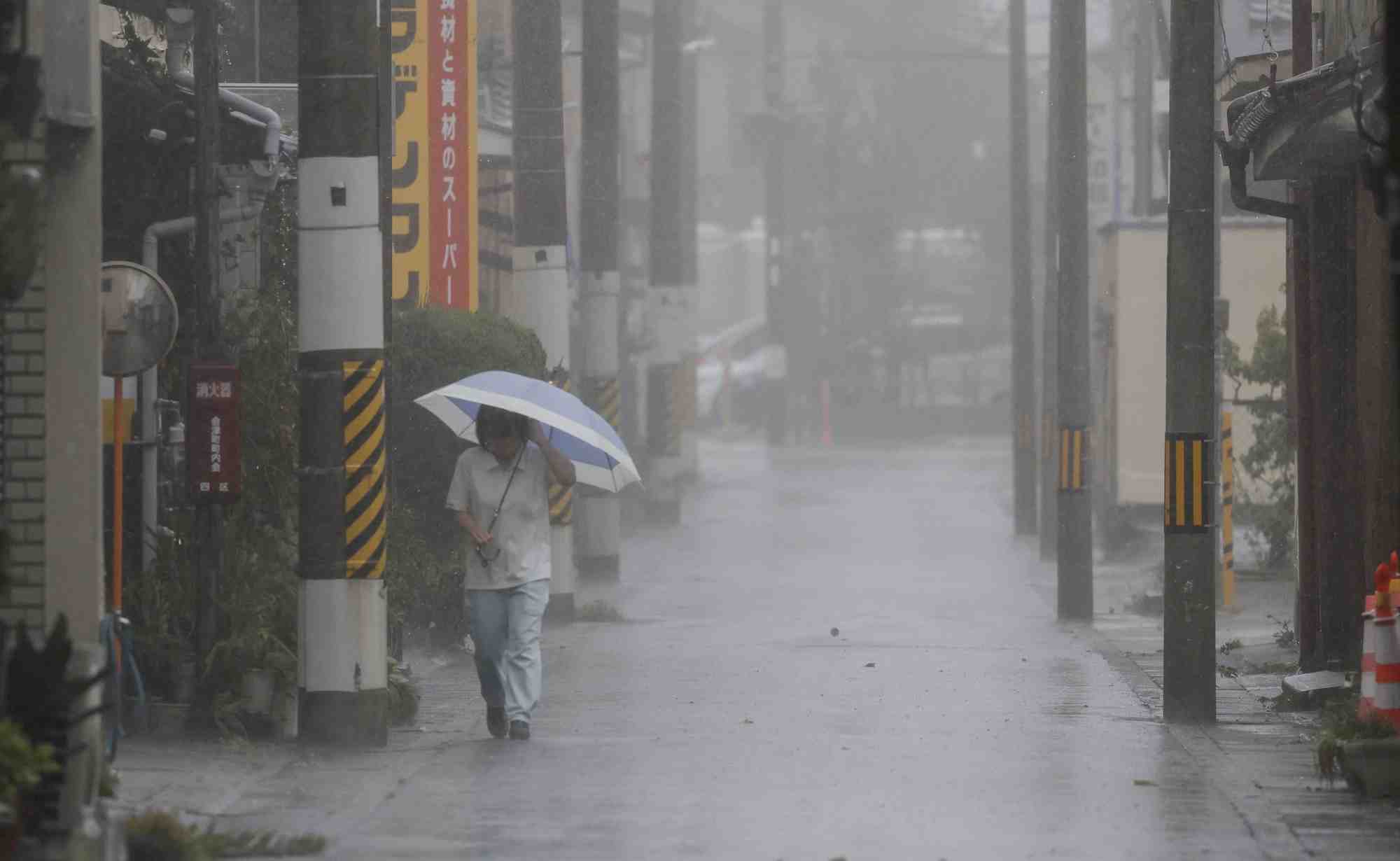 A passerby walks in heavy rain as typhoon lan hits the region tanabe, western japan