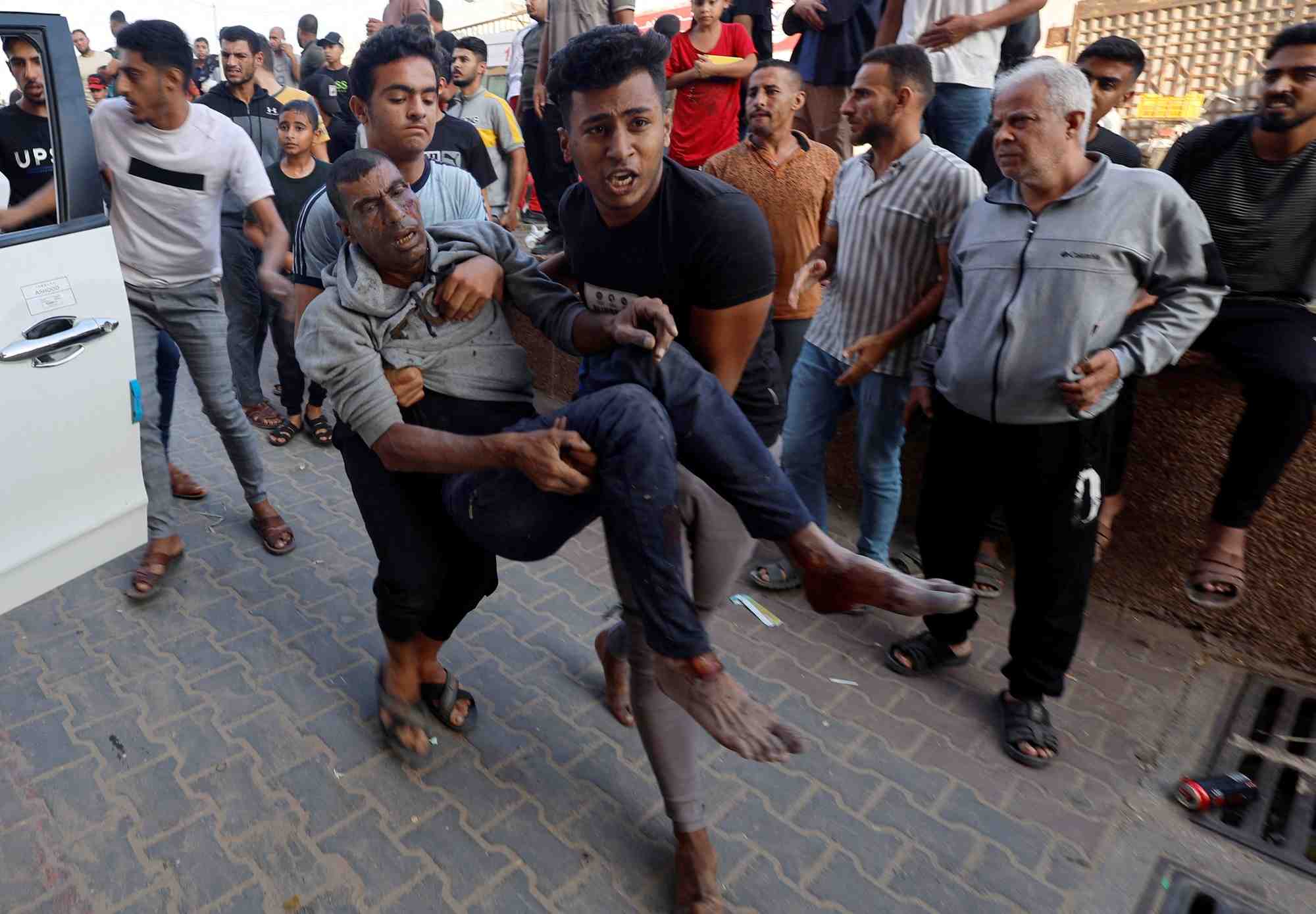 Des civils palestiniens portant un blesse apres une frappe israelienne a khan younis, au sud de gaza