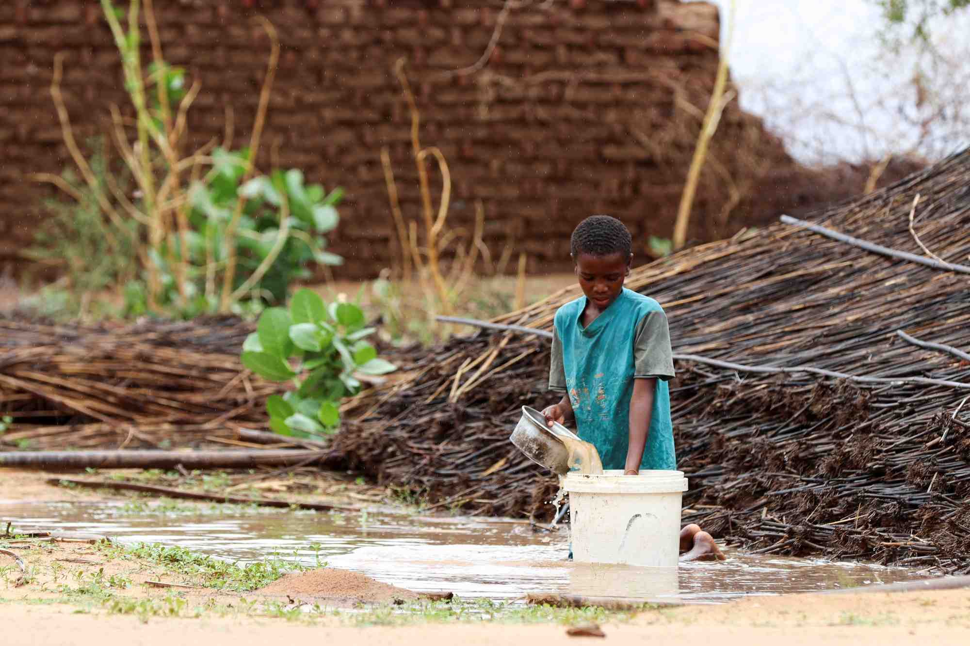 Un enfant soudanais deplace verse de l'eau au camp de zamzam, dans le nord du darfour