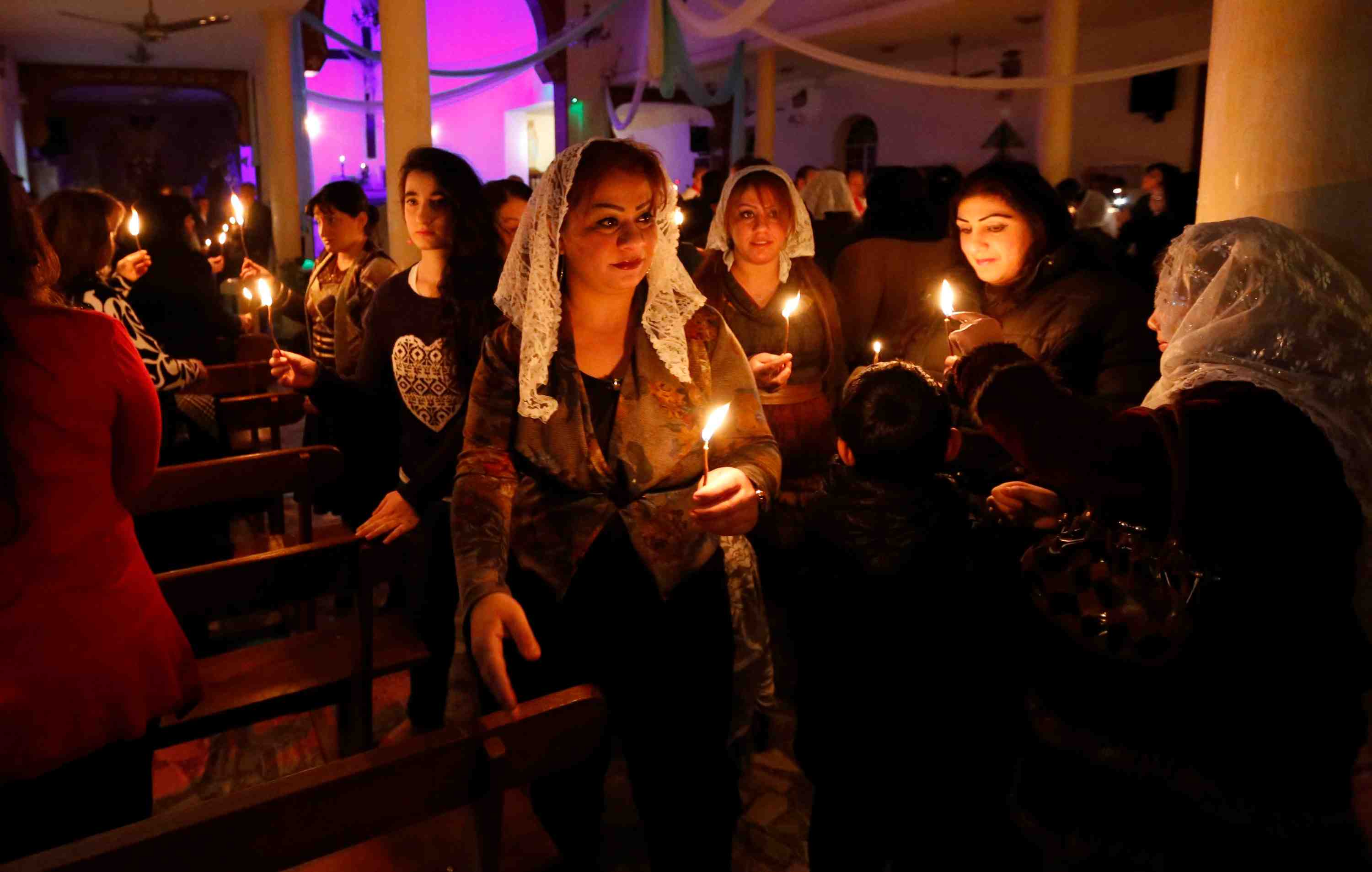 Iraqi christians pray during a mass on christmas eve at sacred heart catholic church in baghdad